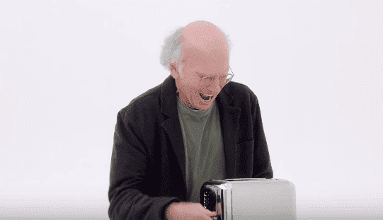 Larry David tries to release the bread in the toaster. | Source: YouTube/HBO.