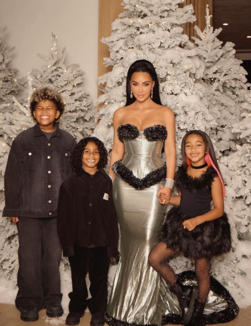 Kim Kardashian, her daughter Chicago, and her sons Saint and Psalm West posing in front of Christmas trees, from a post dated December 27, 2025 | Source: Instagram/kimkardashian