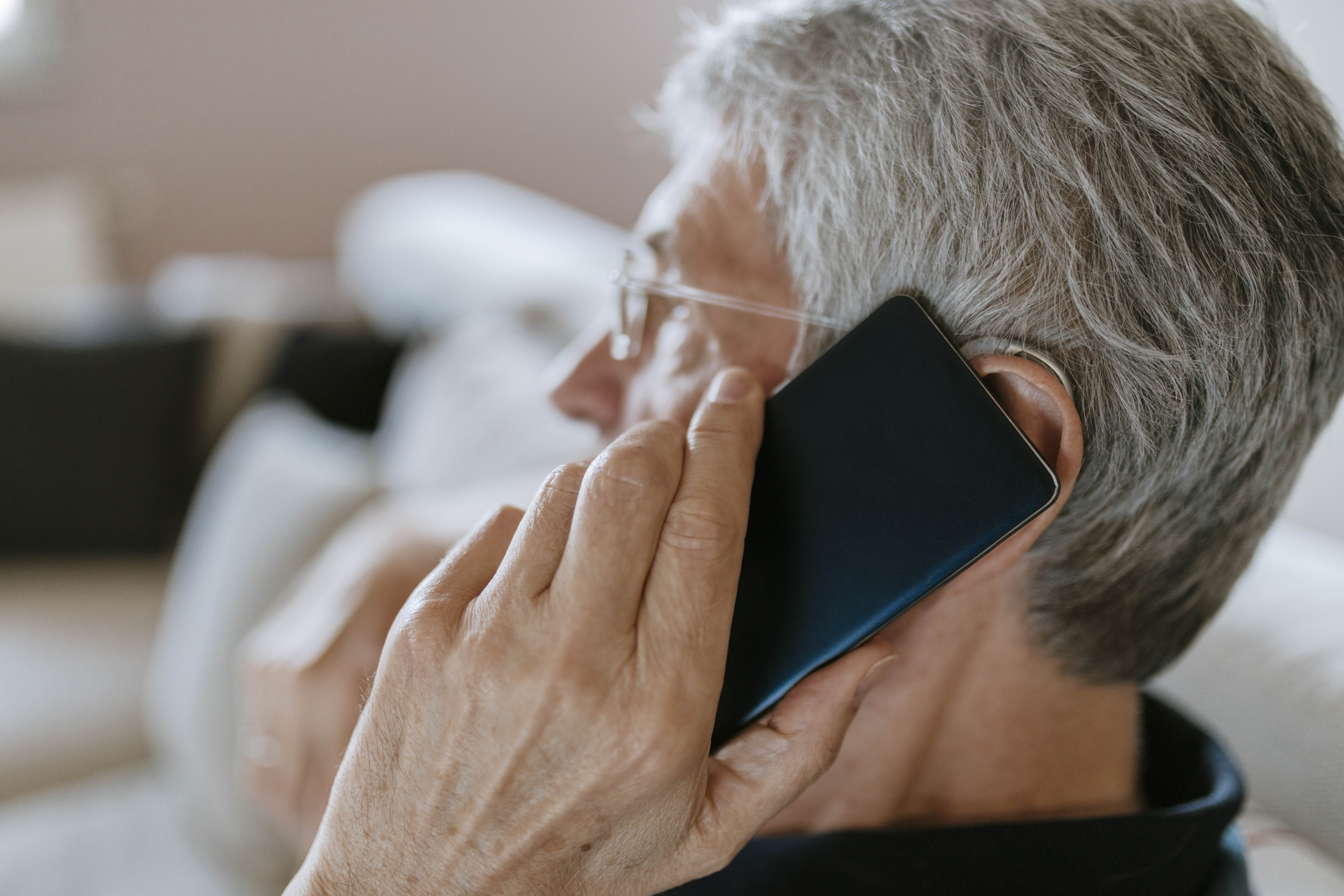 Senior man with hearing aid on cell phone | Source: Getty Images
