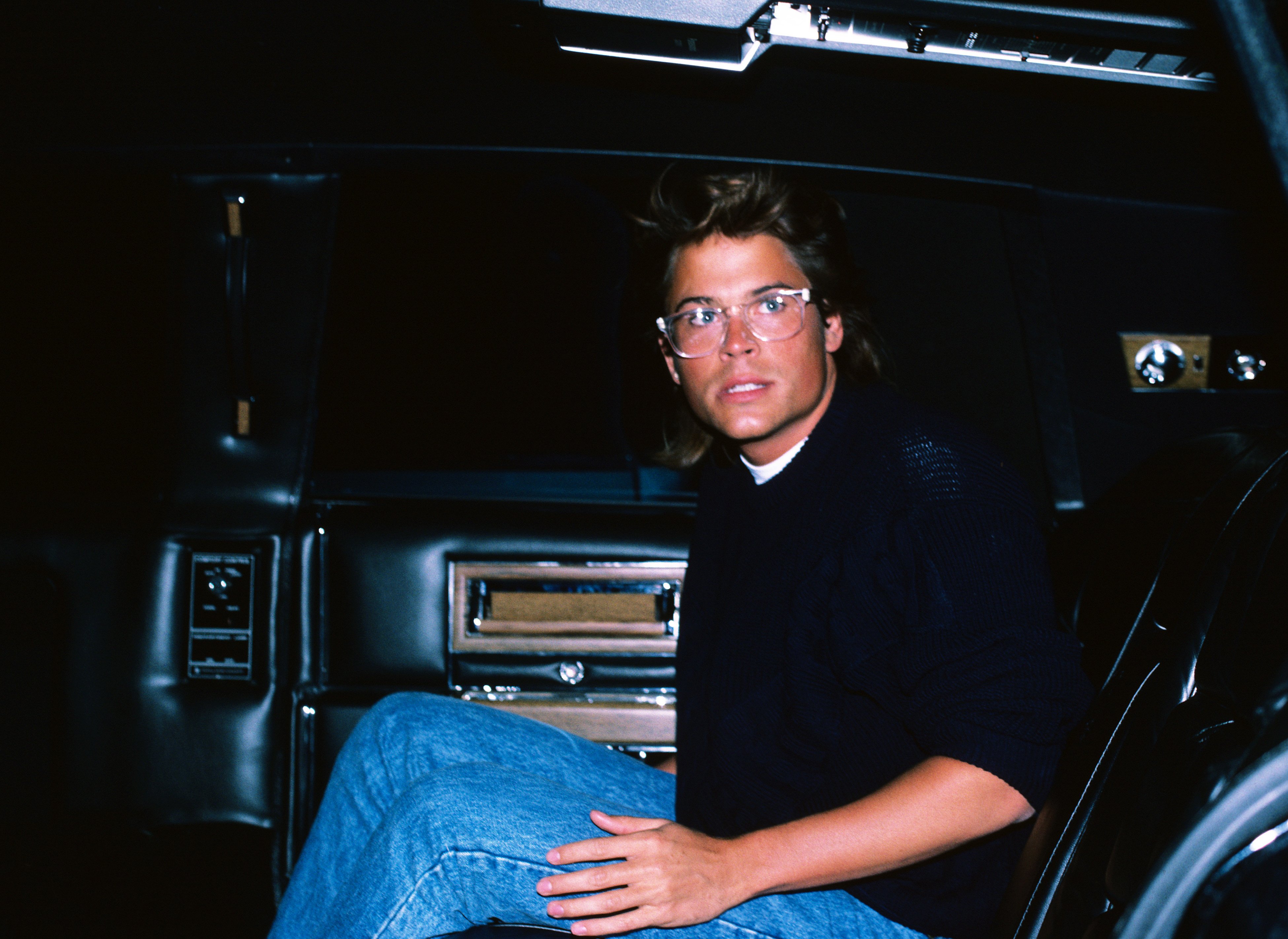 Rob Lowe pictured wearing glasses paired jeans and a blue sweater on June 1, 1985 in New York City. / Source: Getty Images