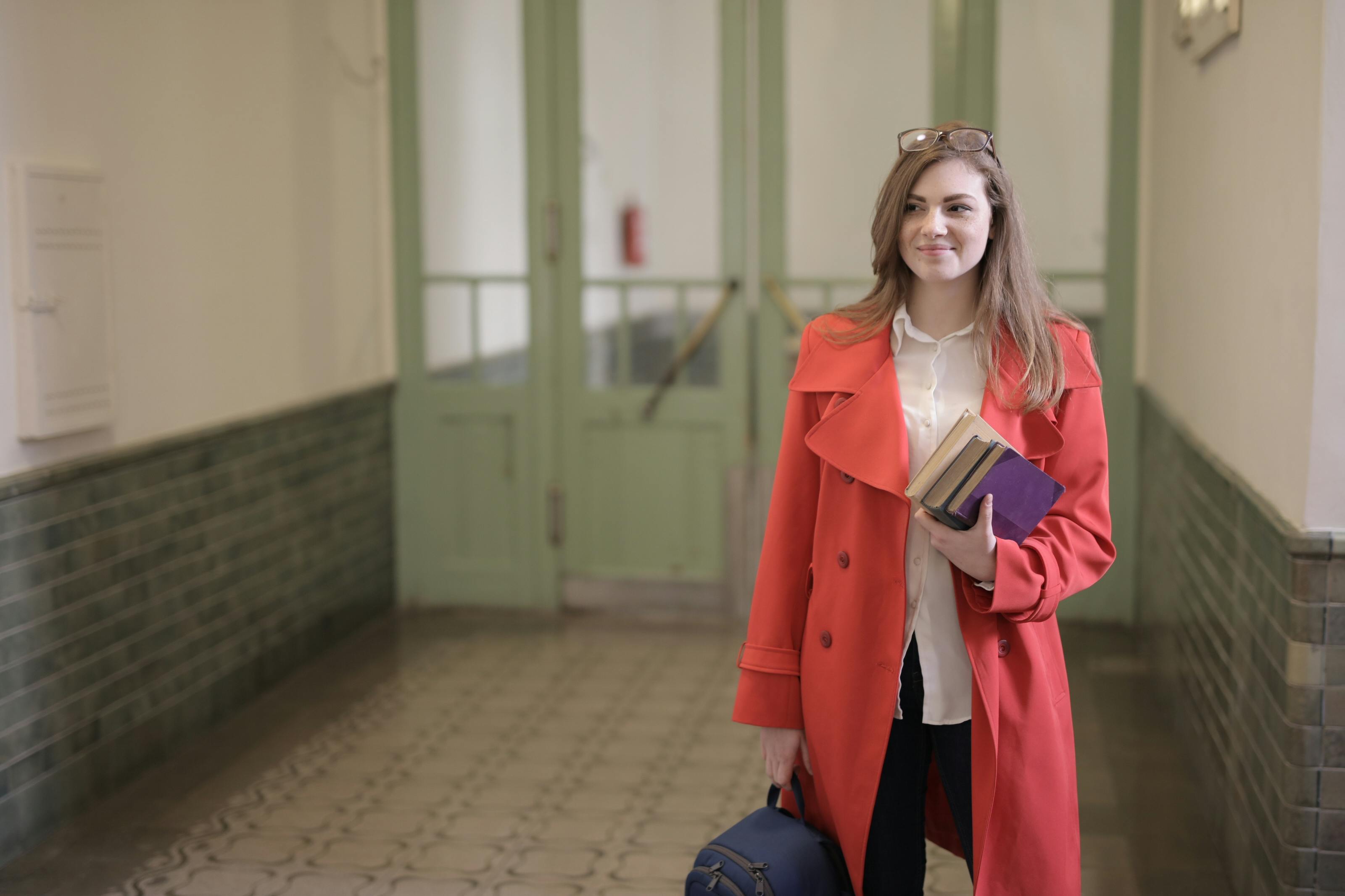 A female student holding books and a backpack | Source: Pexels