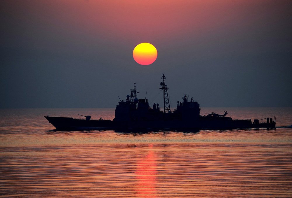 A Navy ship navigates calm waters on a sunset. I Image: Pixabay.