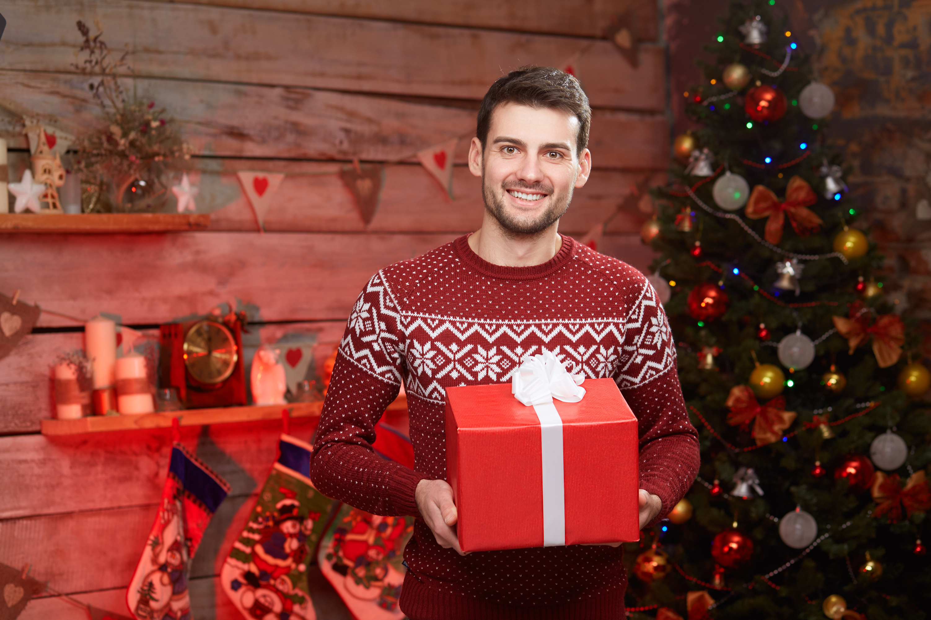 A happy man holding a gift box during Christmas | Source: Shutterstock