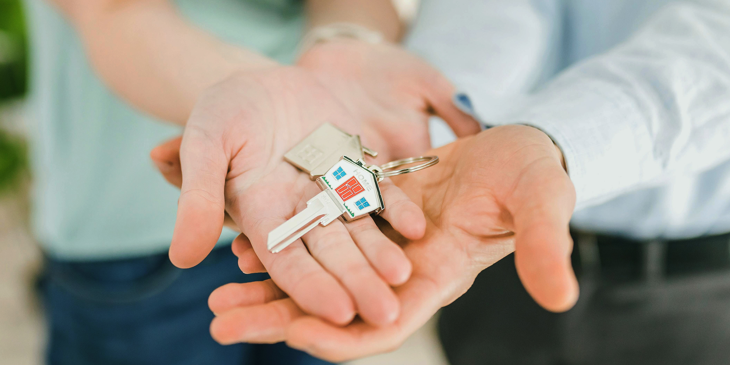 A pair of house keys on a couple's hands | Source: pexels.com/rdne