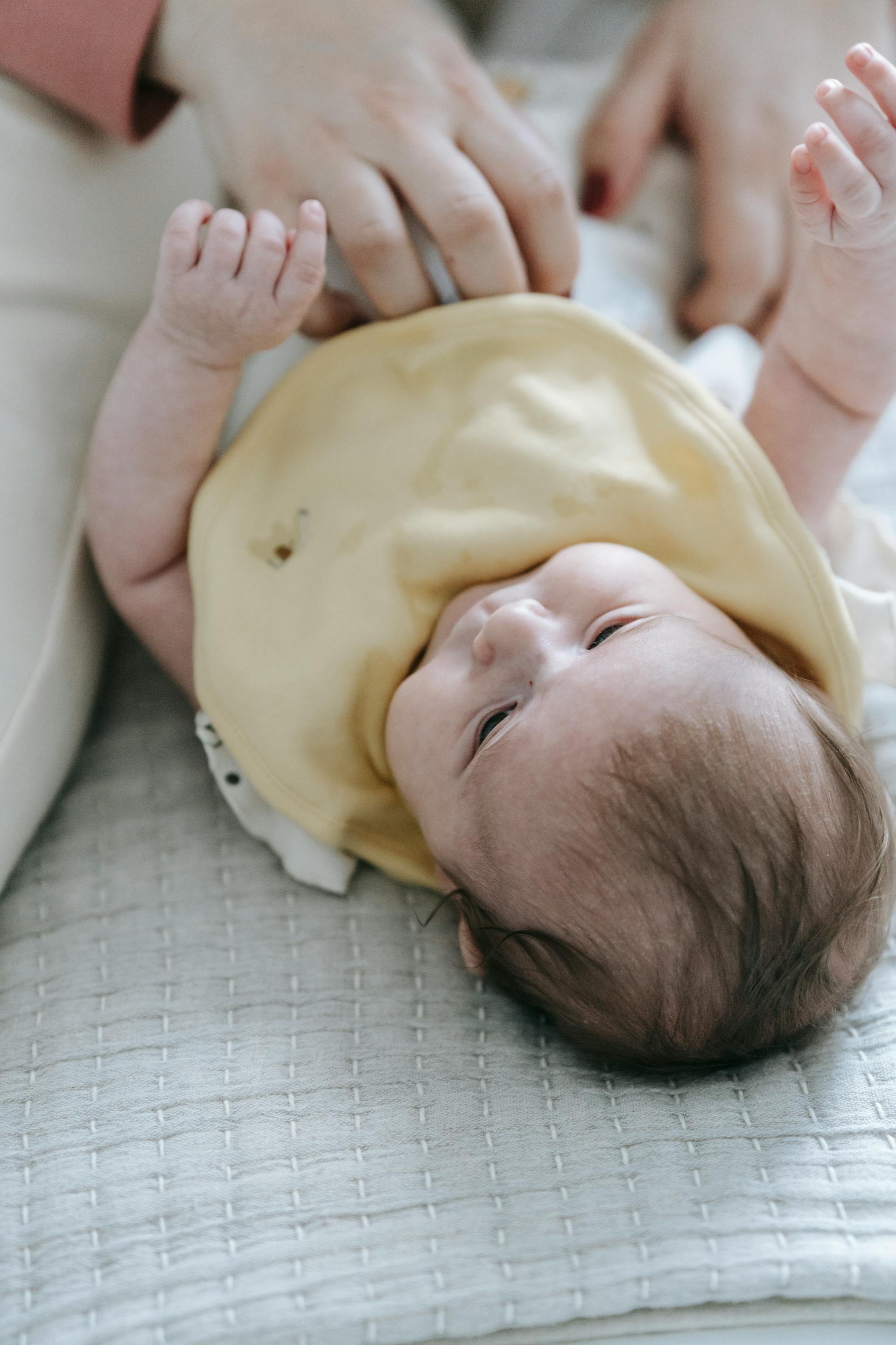 A woman changing a baby's diaper | Source: Pexels