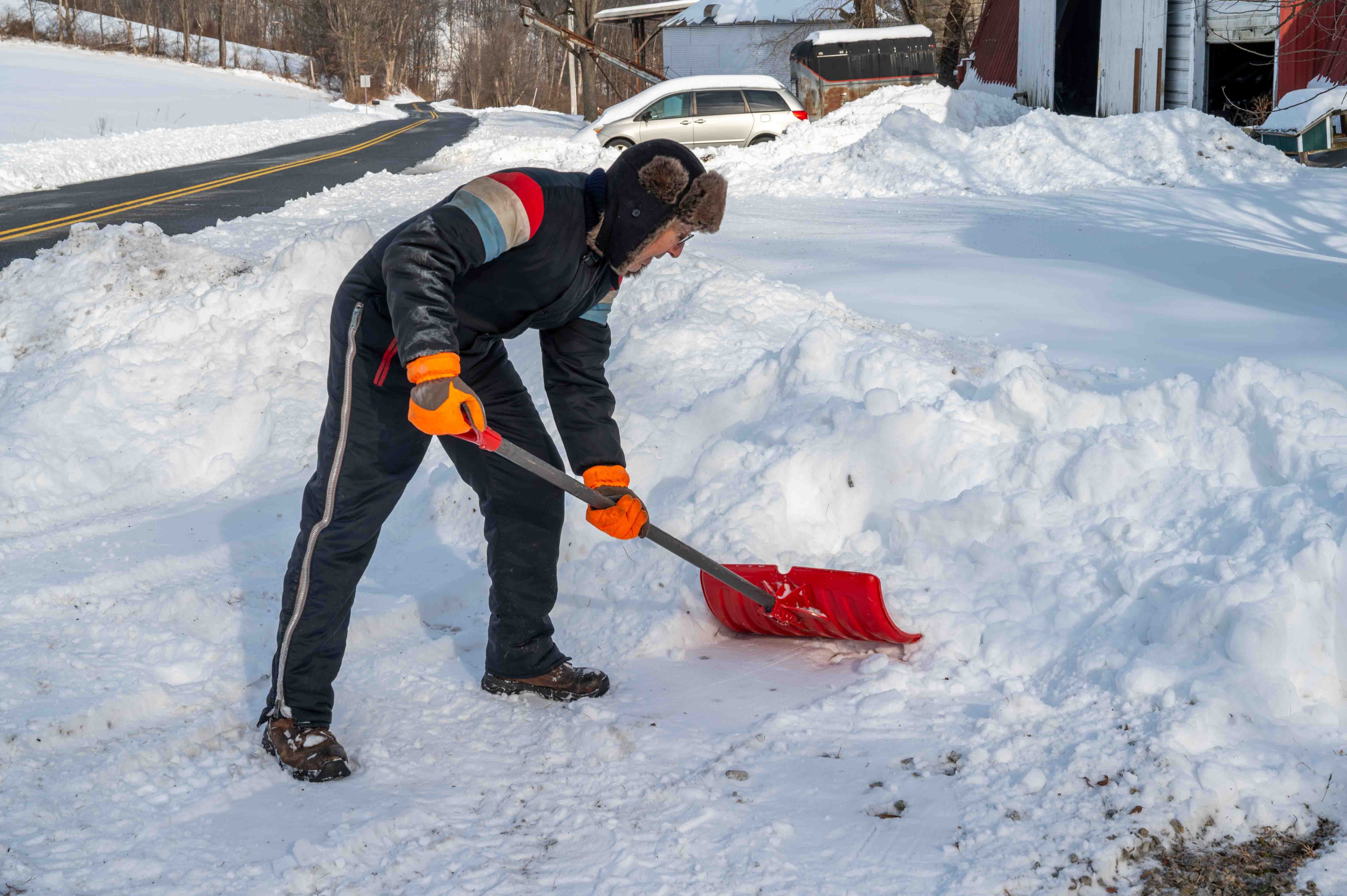 A man in a snowsuit shoveling snow | Source: Shutterstock