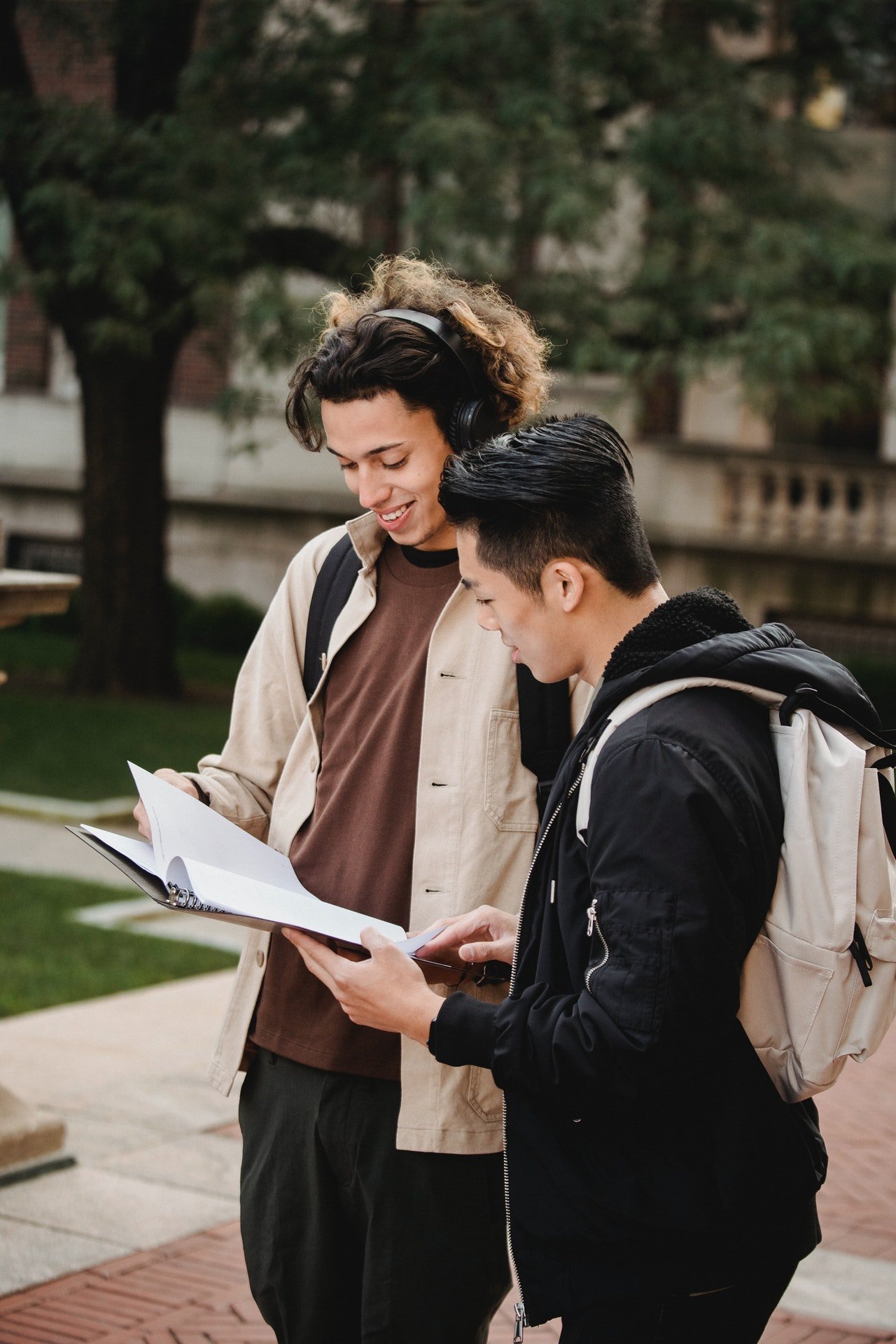 Two students looking at their notebook | Source: Pexels