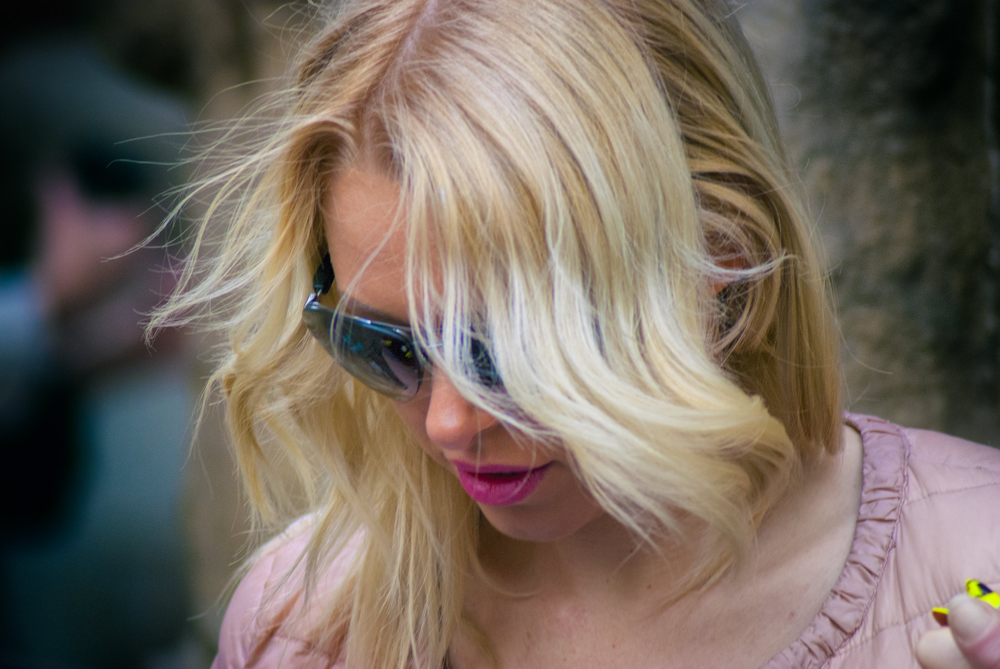 A blonde-haired woman looking down while wearing sunglasses | Source: Flickr