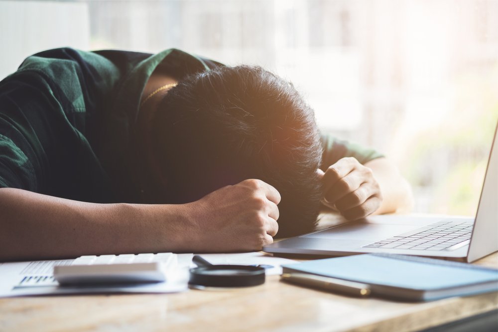 A man suffering burnout syndrome and sleeping at his desk. | Photo: Shutterstock