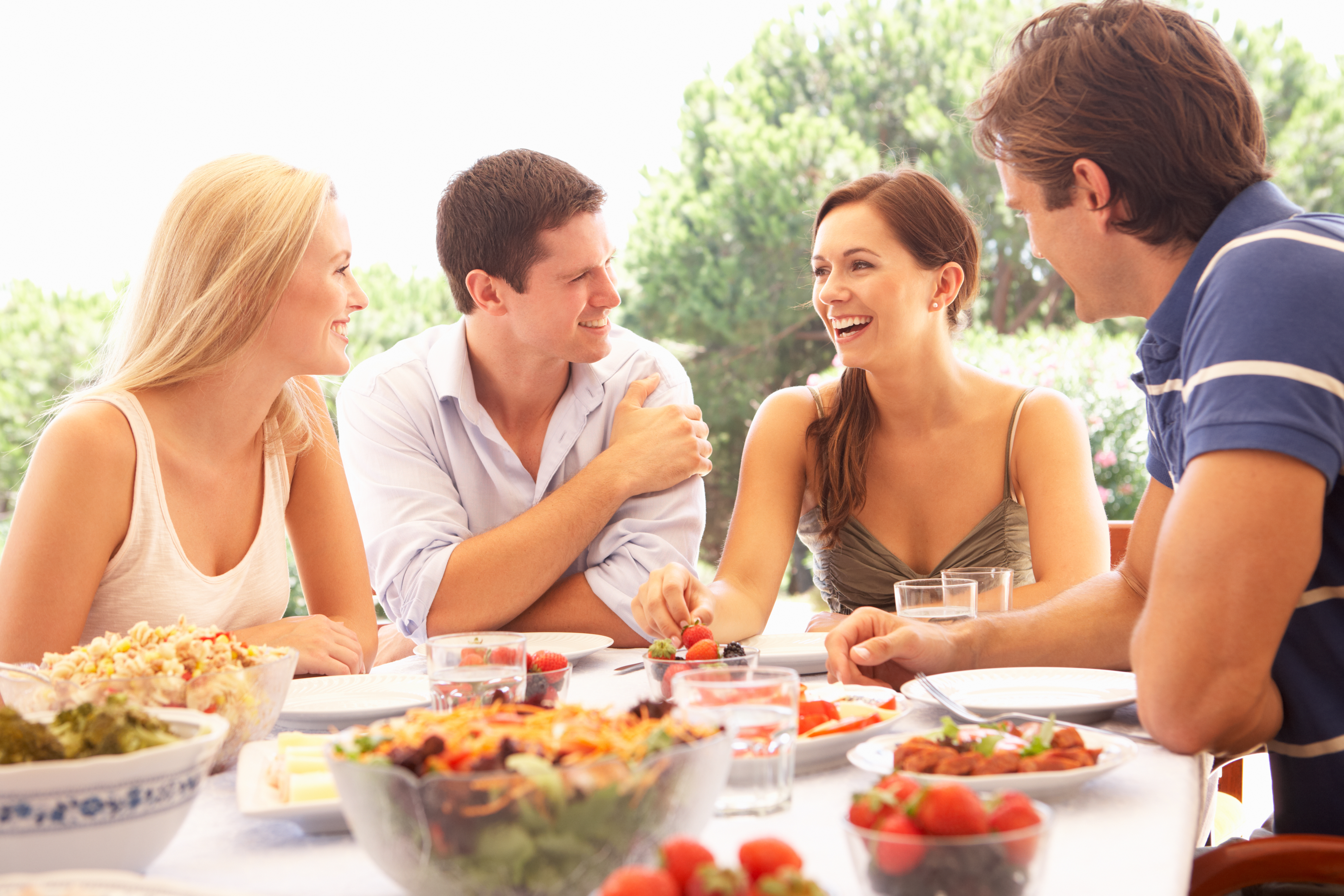 Two young couples eating outdoors | Source: Shutterstock