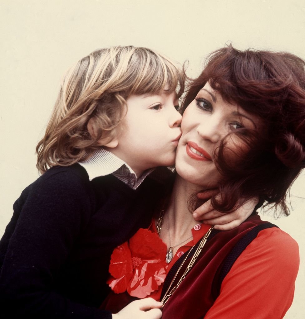 Die deutsche Schauspielerin Iris Berben bekommt von ihrem siebenjährigen Sohn Oliver einen Kuss auf die Wange gedrückt. Aufnahme vom 8.2.1977. (Photo by Istvan Bajzat) | Quelle: Picture alliance via Getty Images