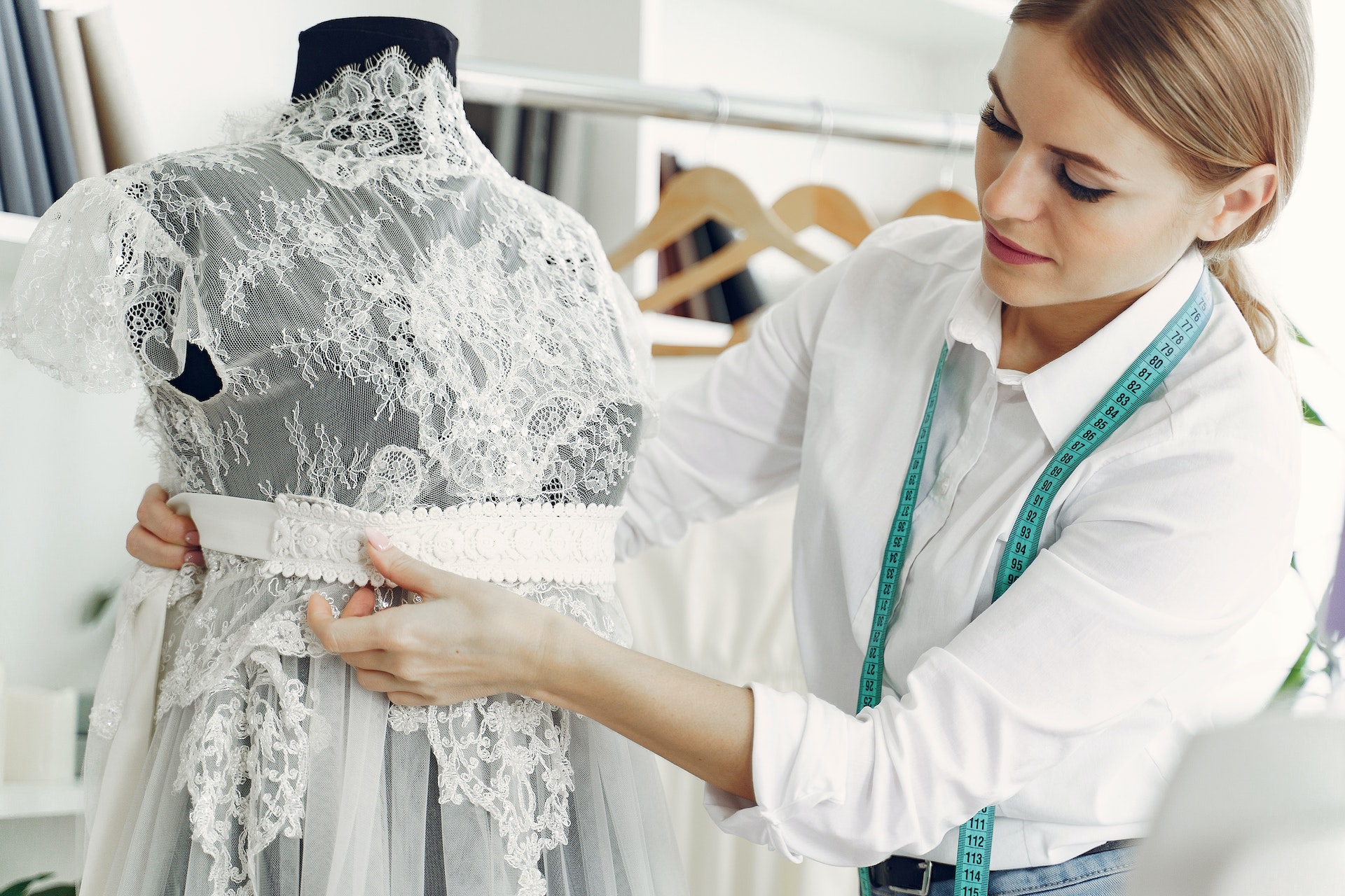 A dressmaker working on a white dress | Source: Pexels