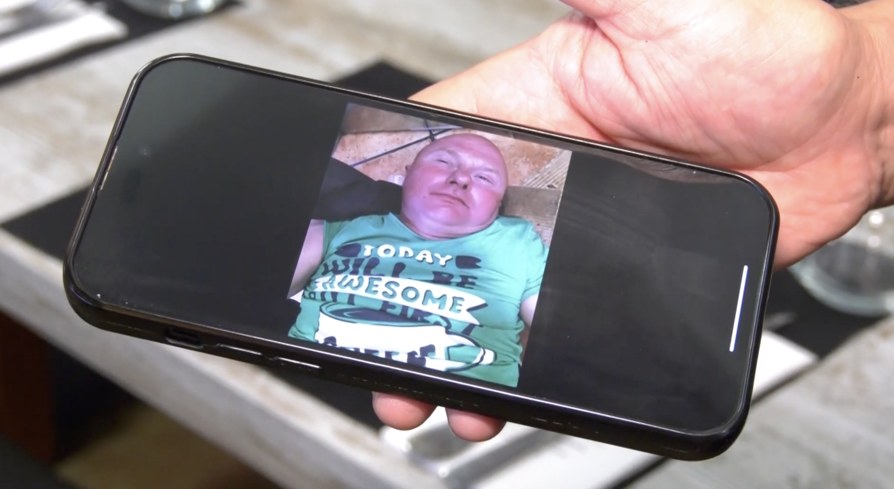 Moisés Doménech, owner of the restaurant El Buen Comer, holding a phone with Aidas' photo, as seen in a video dated September 21, 2023 | Source: youtube.com/12tv_es
