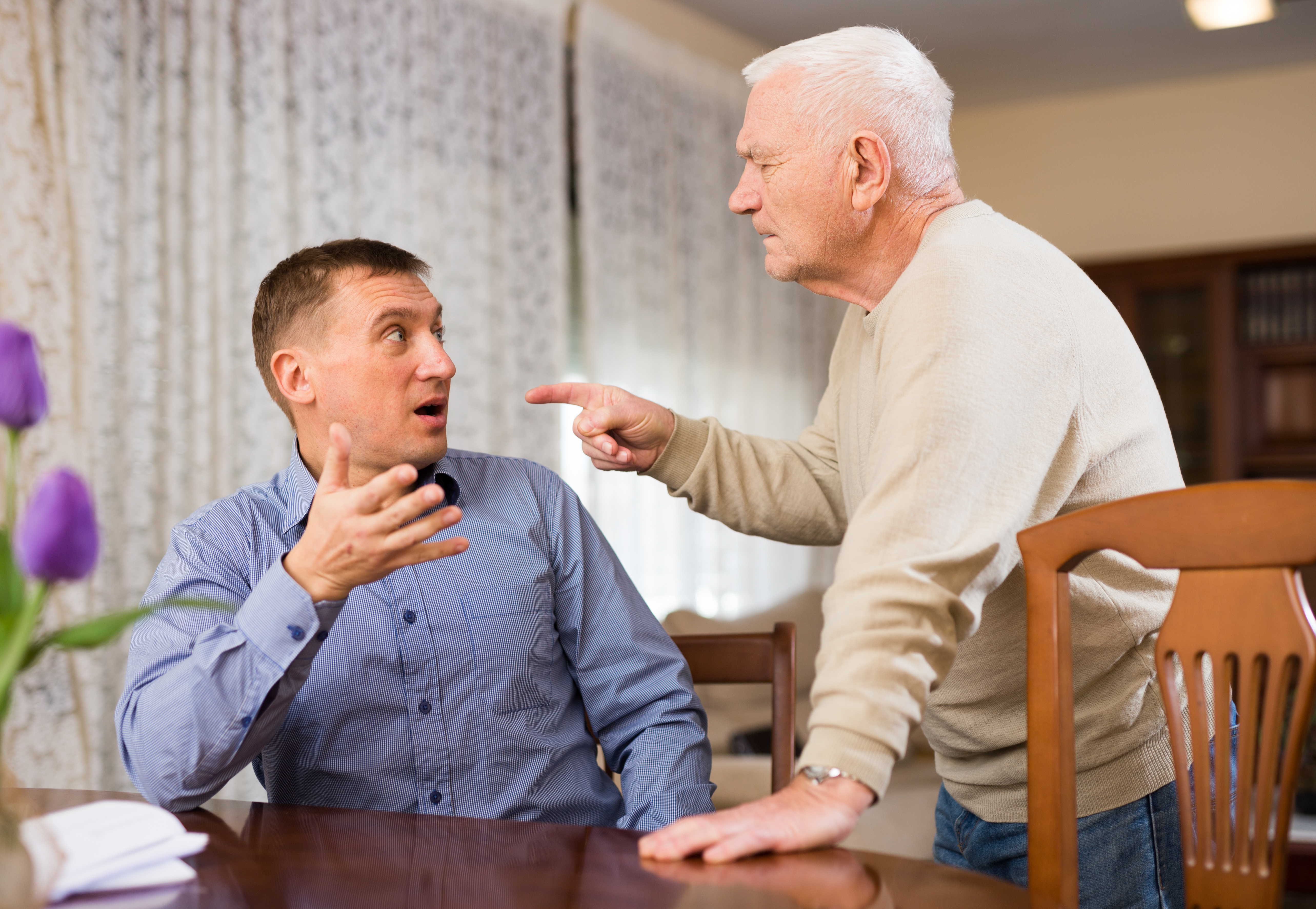 An older man and a younger man arguing | Source: Shutterstock