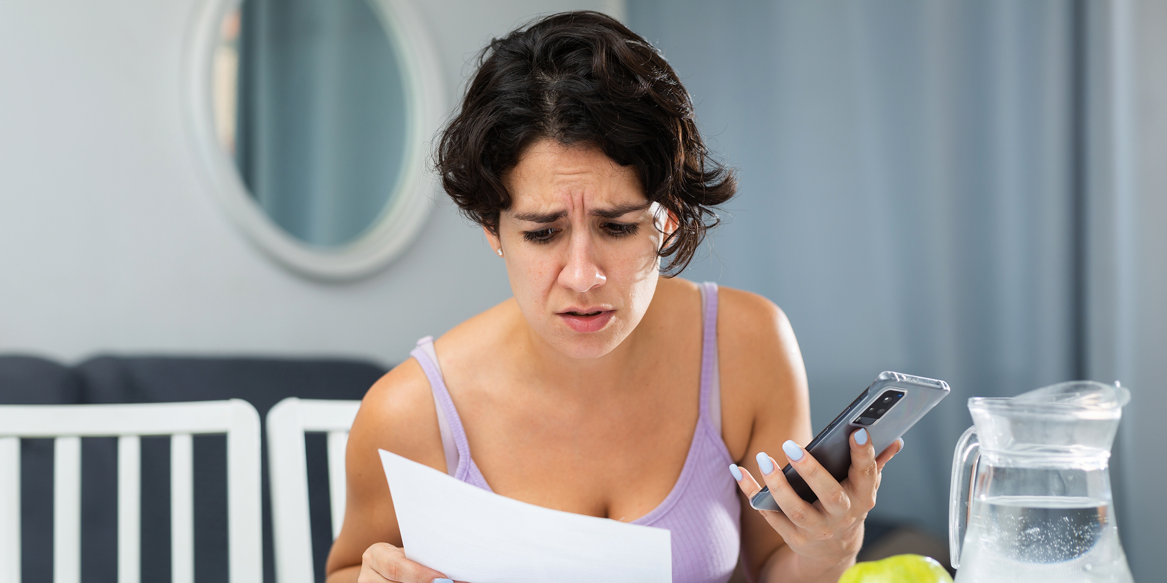 A frowning woman studying a piece of paper | Source: Shutterstock