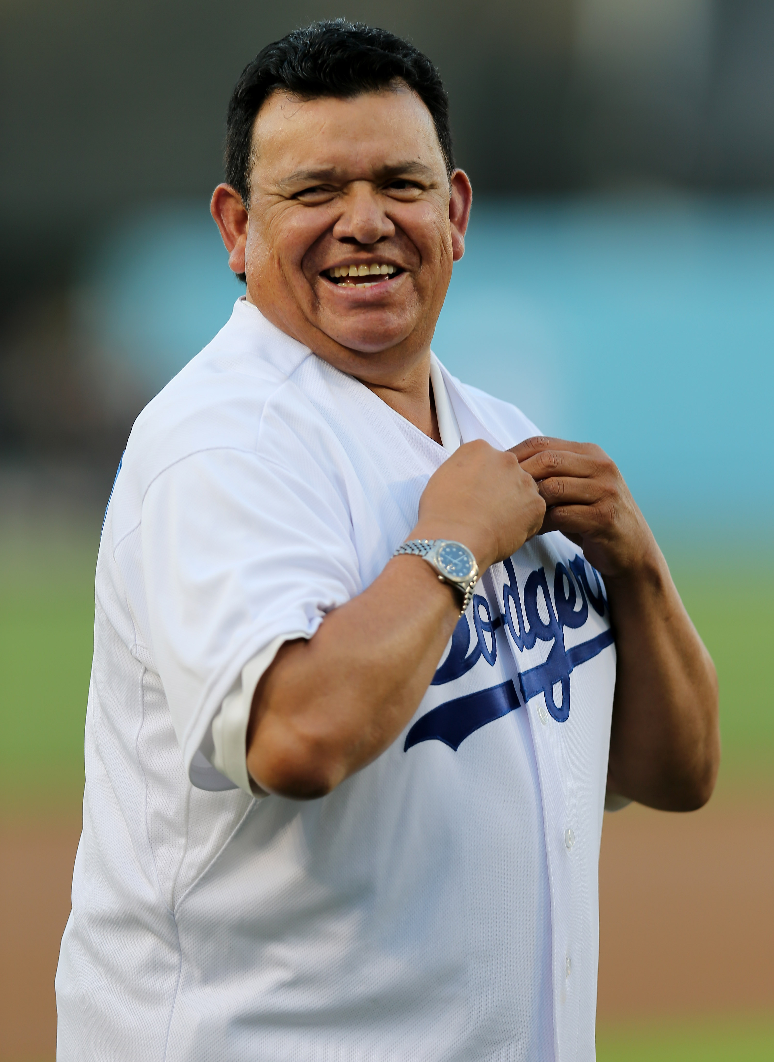 Fernando Valenzuela laughs as he puts on a Dodger jersey for the pre-game ceremonies of the game between the Colorado Rockies and the Los Angeles Dodgers at Dodger Stadium in Los Angeles, California, on September 29, 2012 | Source: Getty Images