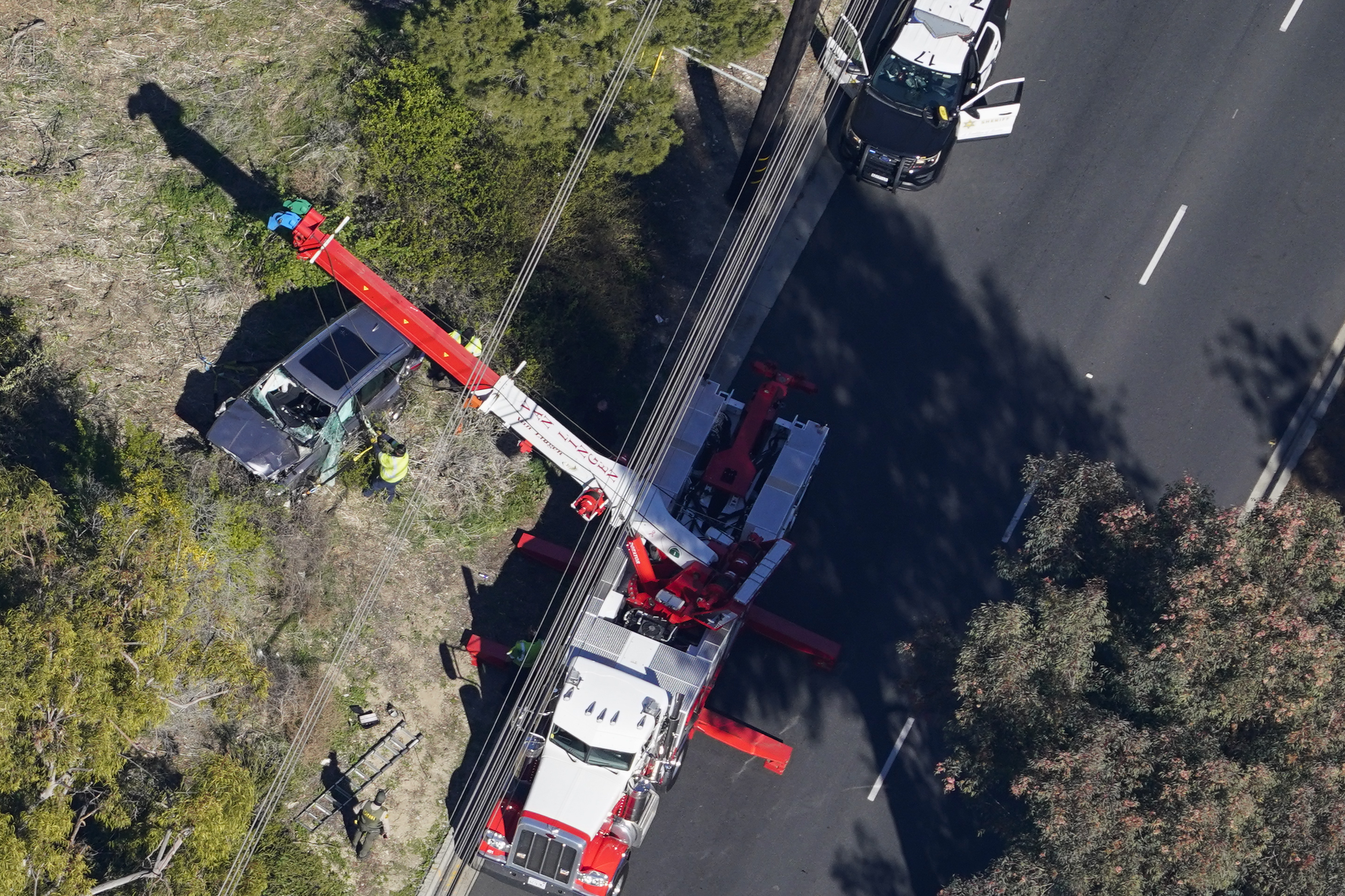 Workers move a vehicle after a rollover accident involving golfer Tiger Woods on February 23, 2021, in Rancho Palos Verdes, California | Source: Getty Images