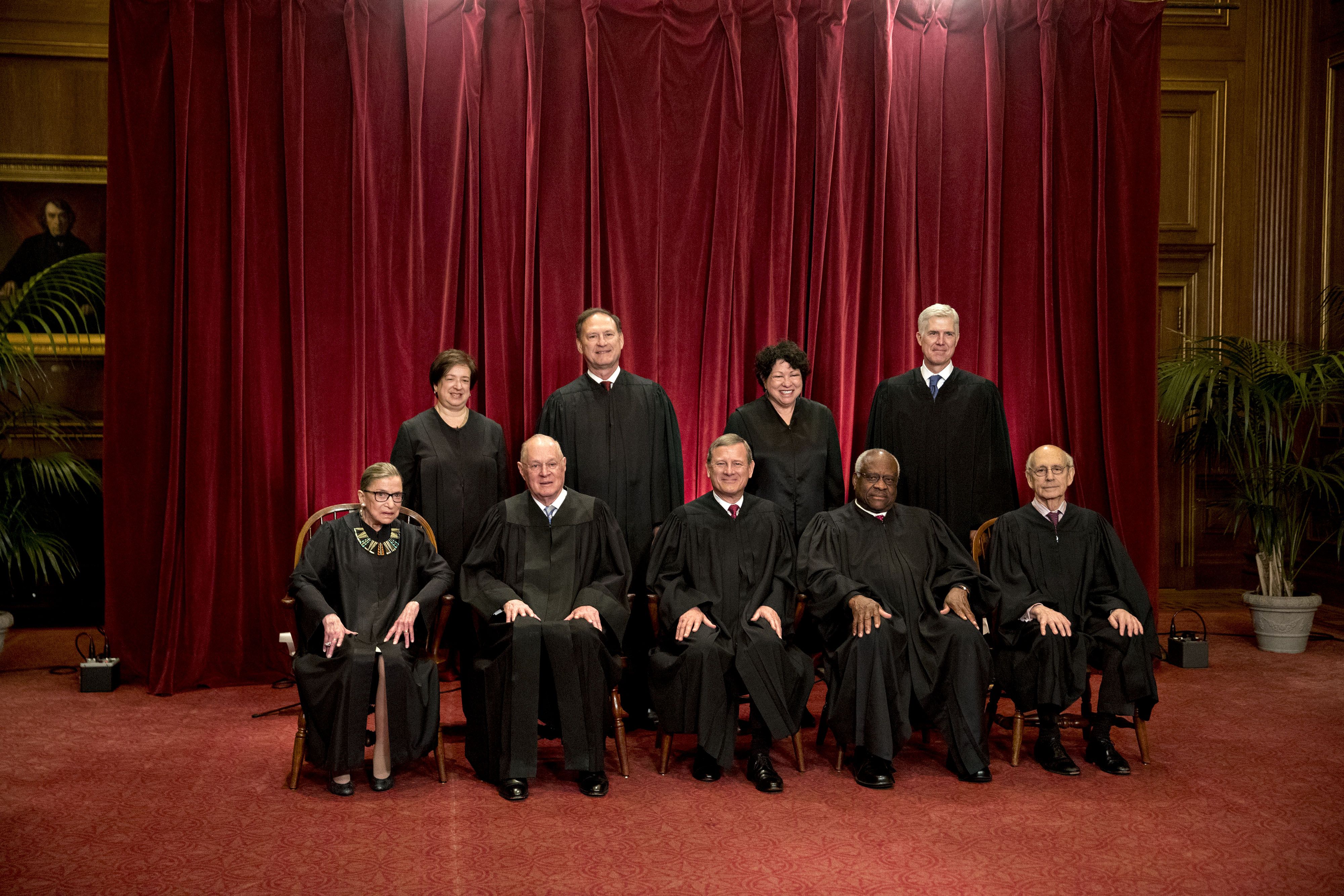 (L-R) Associate Justice Ruth Bader Ginsburg, Associate Justice Anthony Kennedy, Chief Justice John Roberts, Associate Justice Clarence Thomas, and Associate Justice Stephen Breyer. Standing left to right; Associate Justice Elena Kagan, Associate Justice Samuel Alito Jr., Associate Justice Sonia Sotomayor, and Associate Justice Neil Gorsuch during their formal group photograph in the East Conference Room of the Supreme Court in Washington, D.C., U.S., on Thursday, June 1, 2017. | Source: Getty Images
