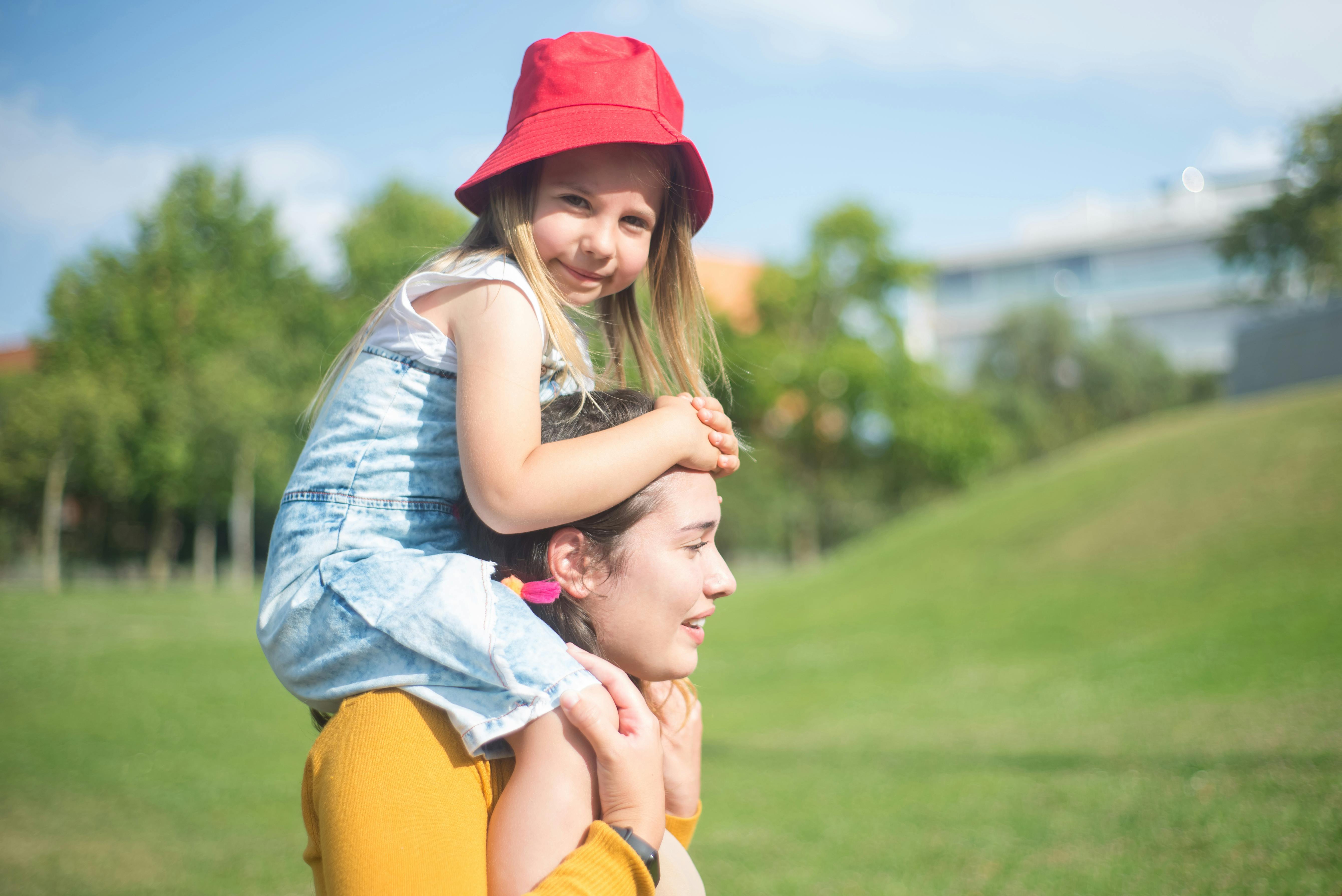 A woman carrying a child on her shoulders | Source: Pexels