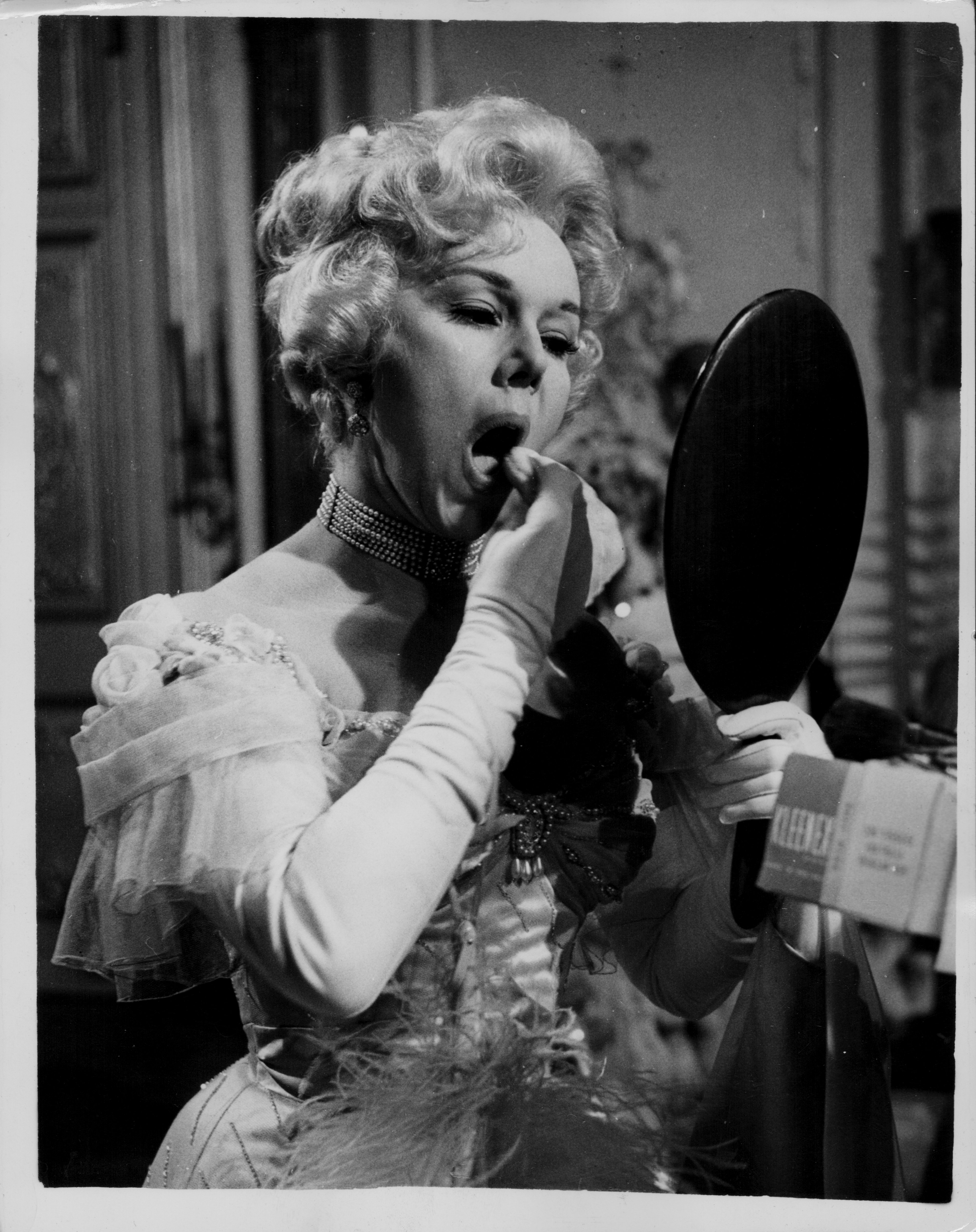 Eva Gabor applying on make-up before shooting a scene. | Photo: Getty Images