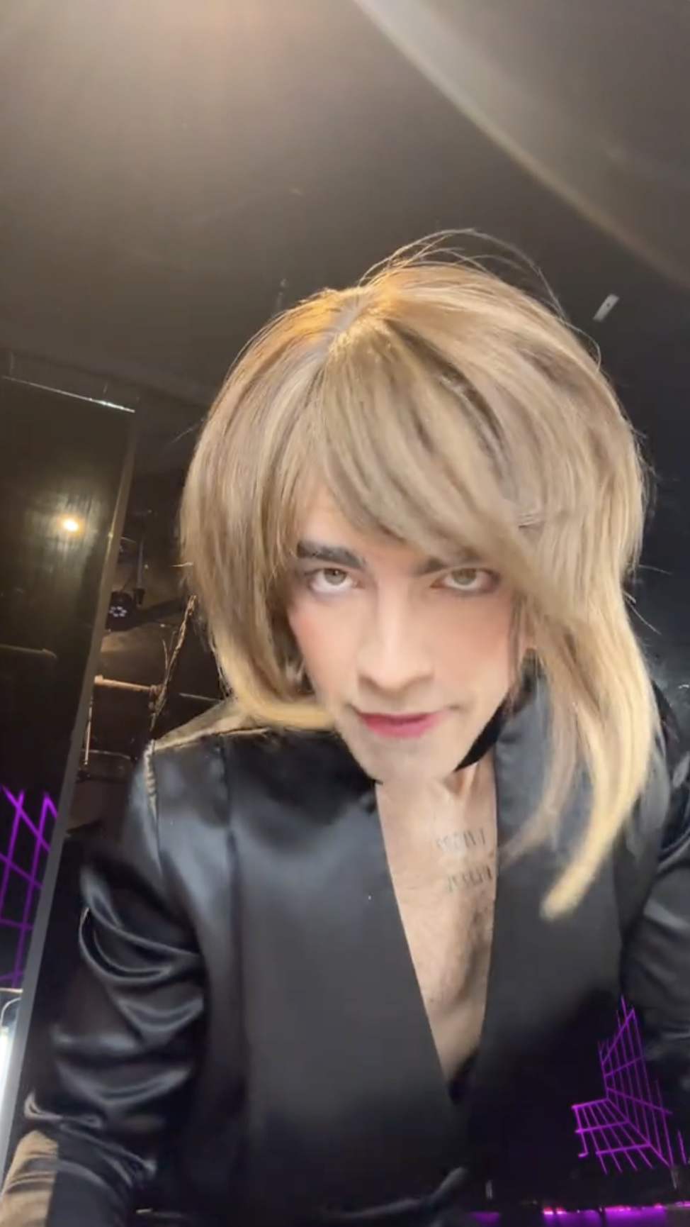 Joe Jonas's TikTok video of him wearing a blond wig and a black dress with a plunging detail | Source: TikTok.com/@joejonas