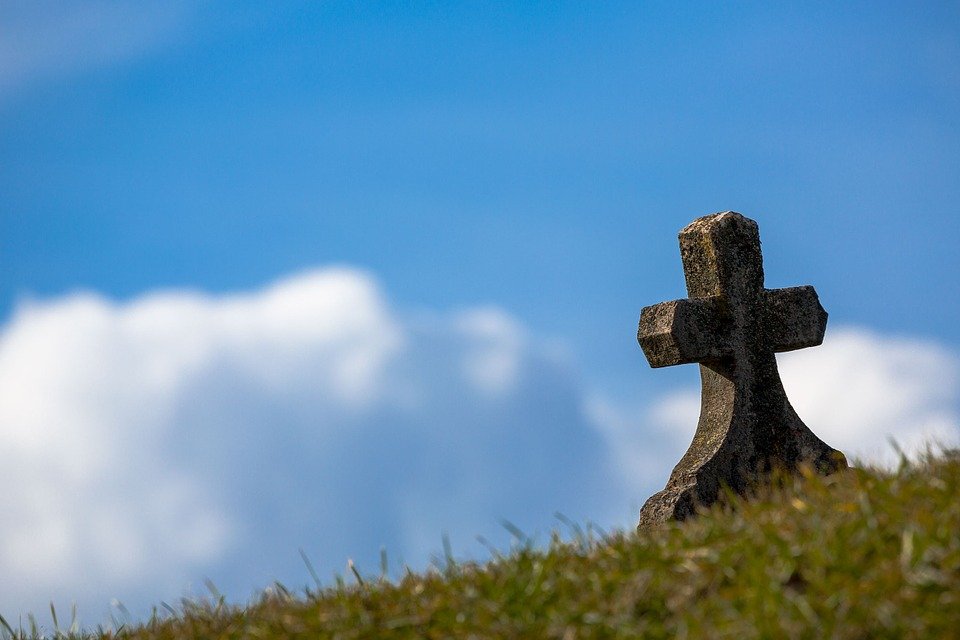 Ein Kreuz auf einem Grab an einem sonnigen Tag. | Quelle: Pixabay