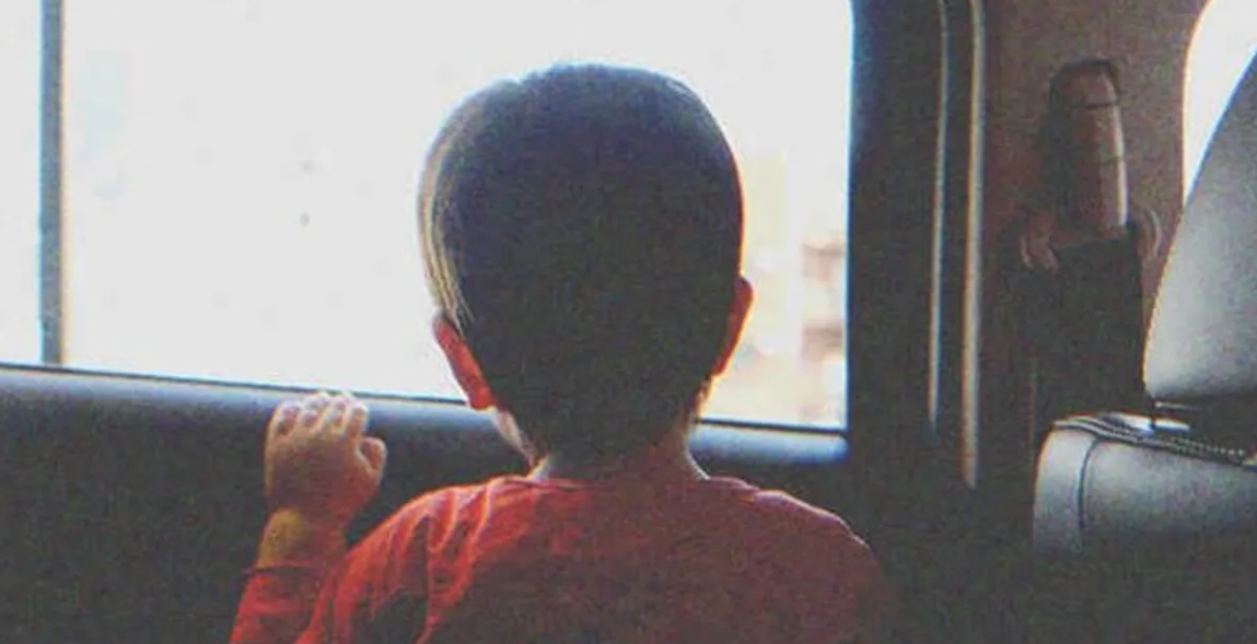 A little boy looking out a window | Source: Shutterstock