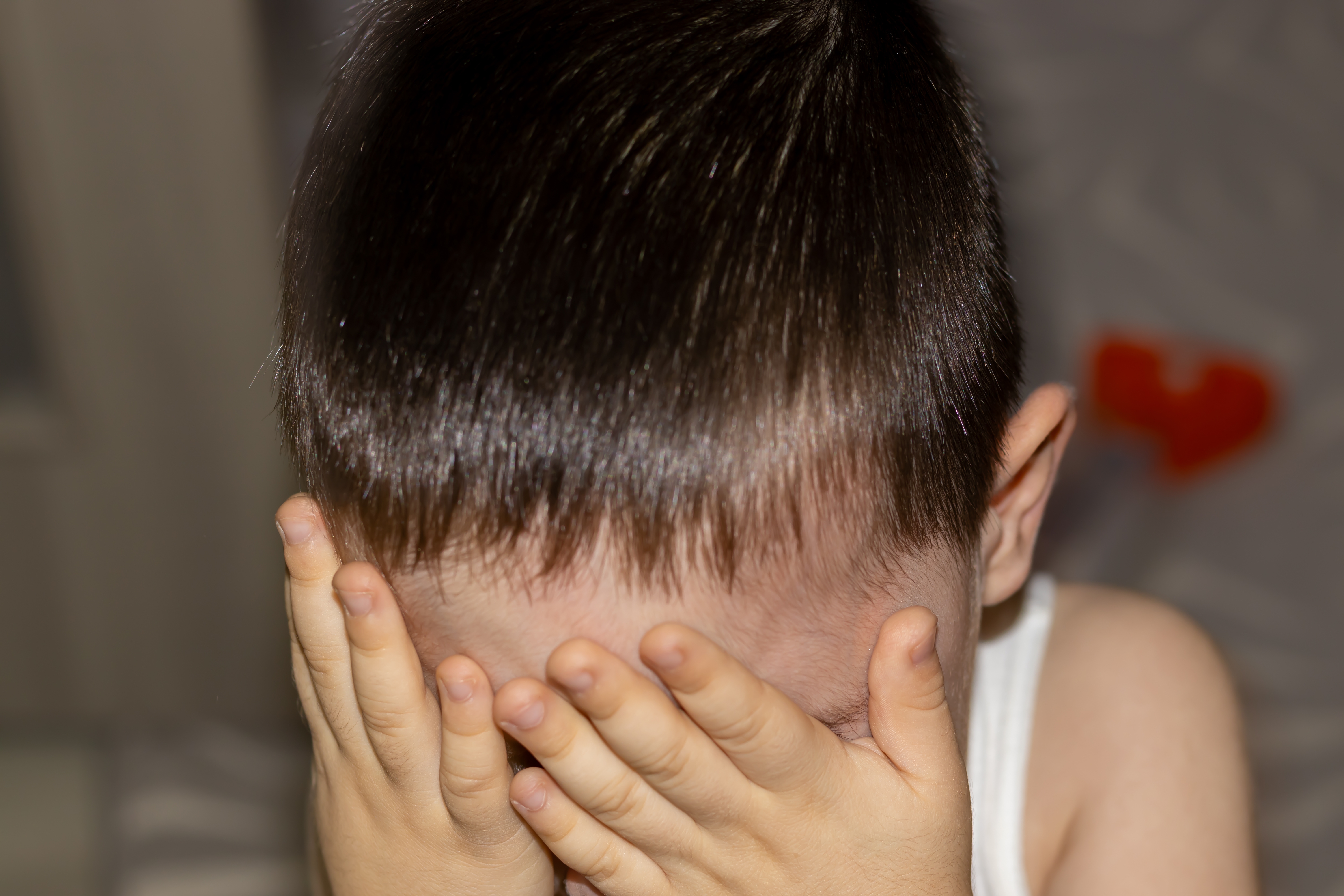 A child hiding his face | Source: Shutterstock