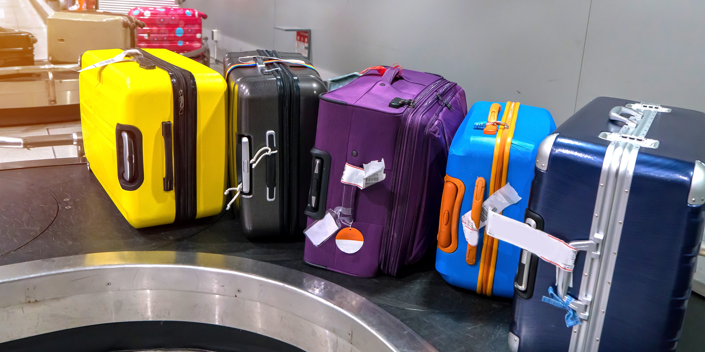 Several travel bags on a conveyor belt | Source: Shutterstock