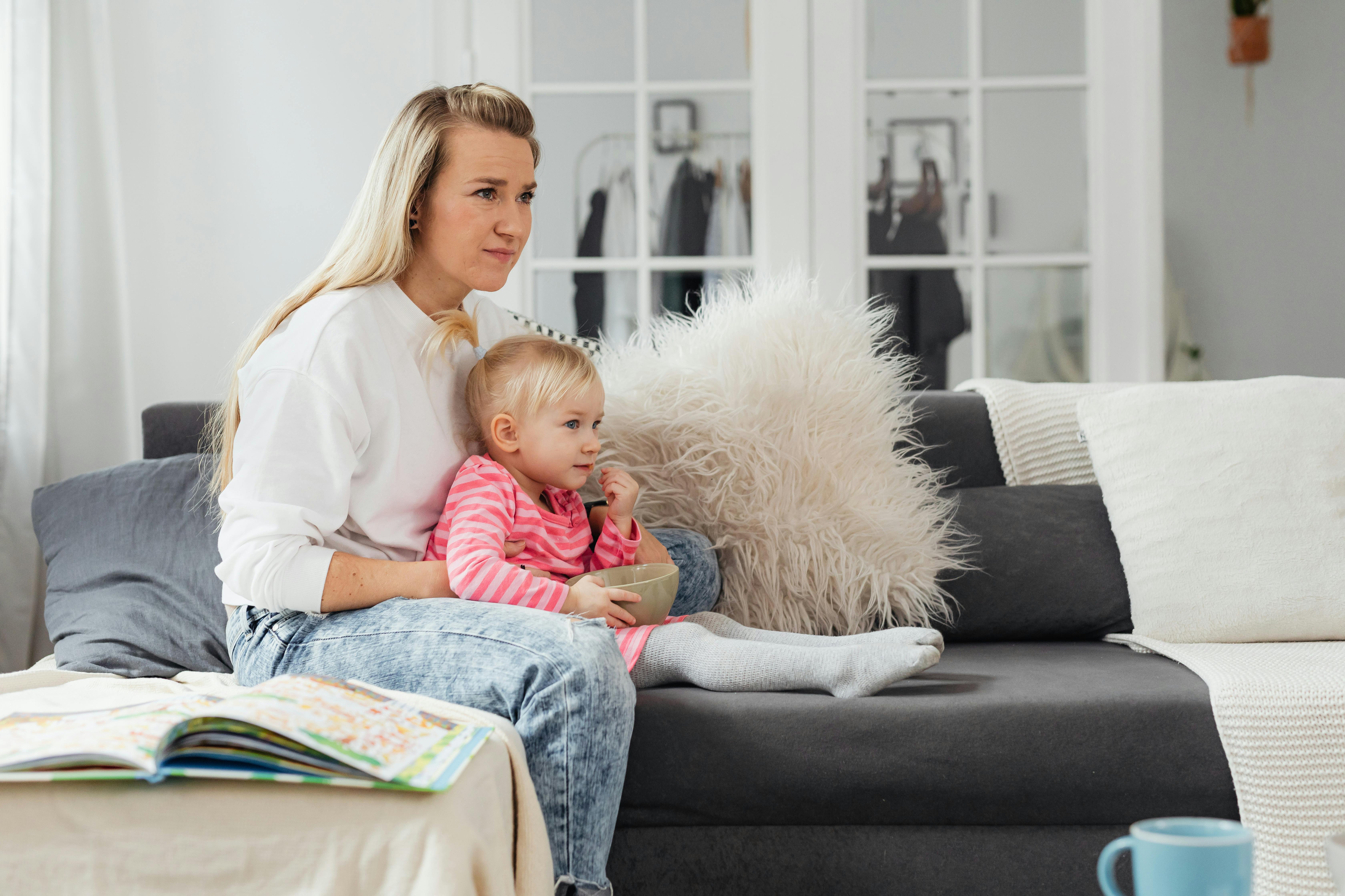 A woman and child sitting on a couch | Source: Pexels