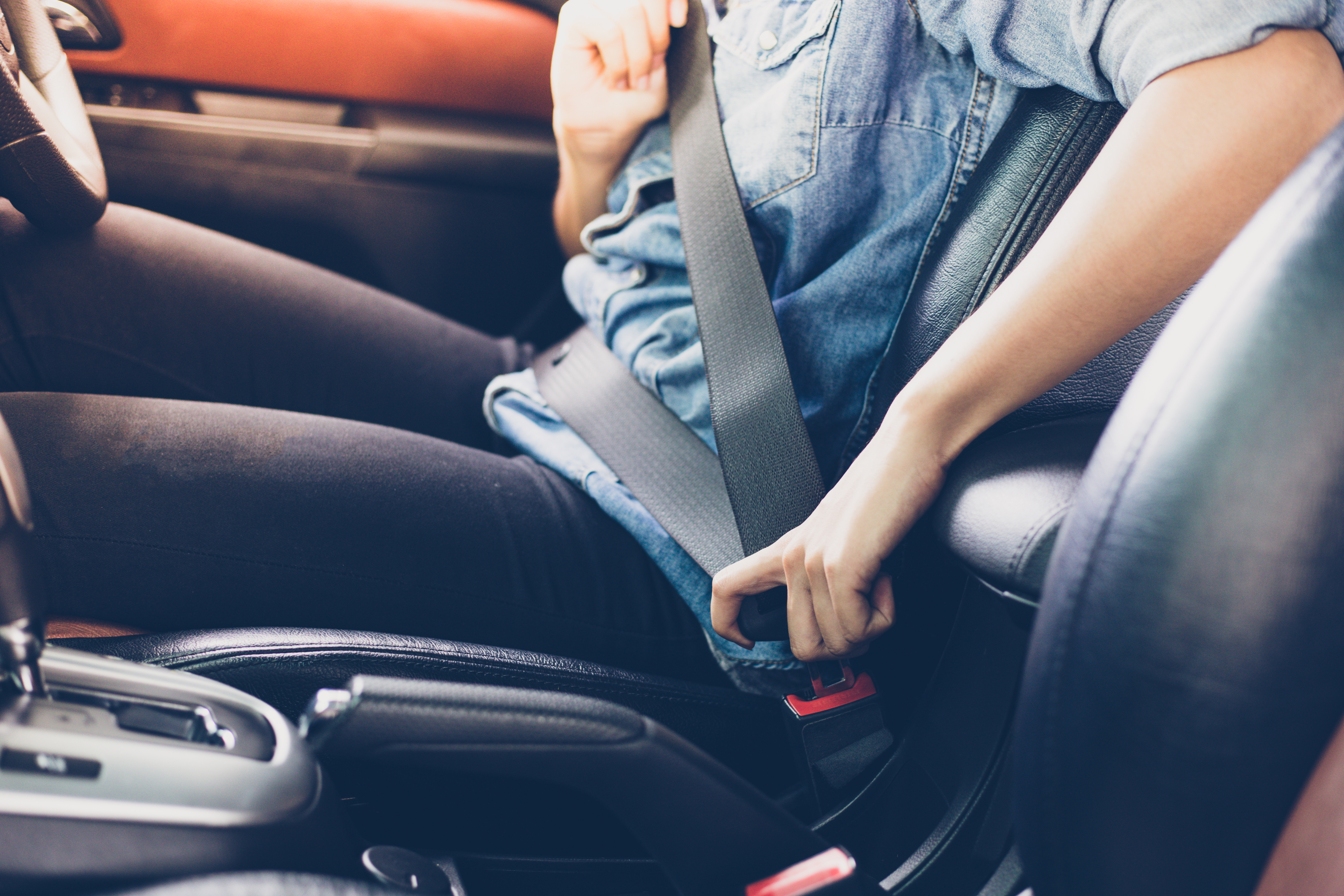 Woman unfastening seat belt in the car. | Source: Shutterstock