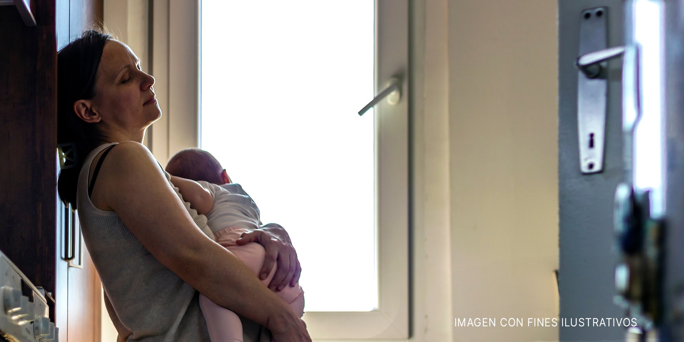 Mujer agotada con un bebé en brazos | Foto: Shutterstock