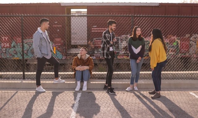 Group of five teenagers in front of chain link fence | Source: Unsplash