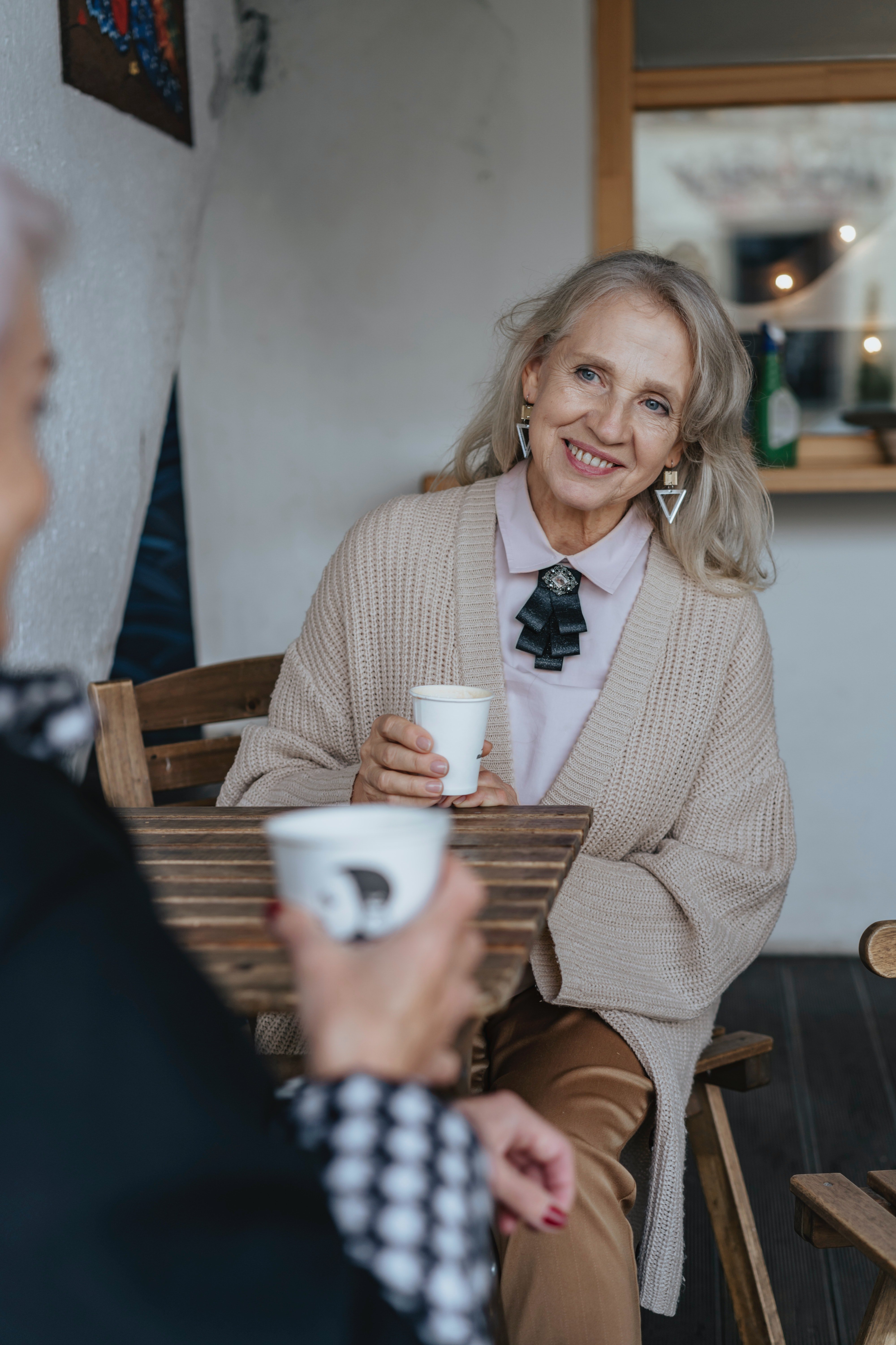 Una mujer mayor comparte un café con alguien. | Foto: Pexels