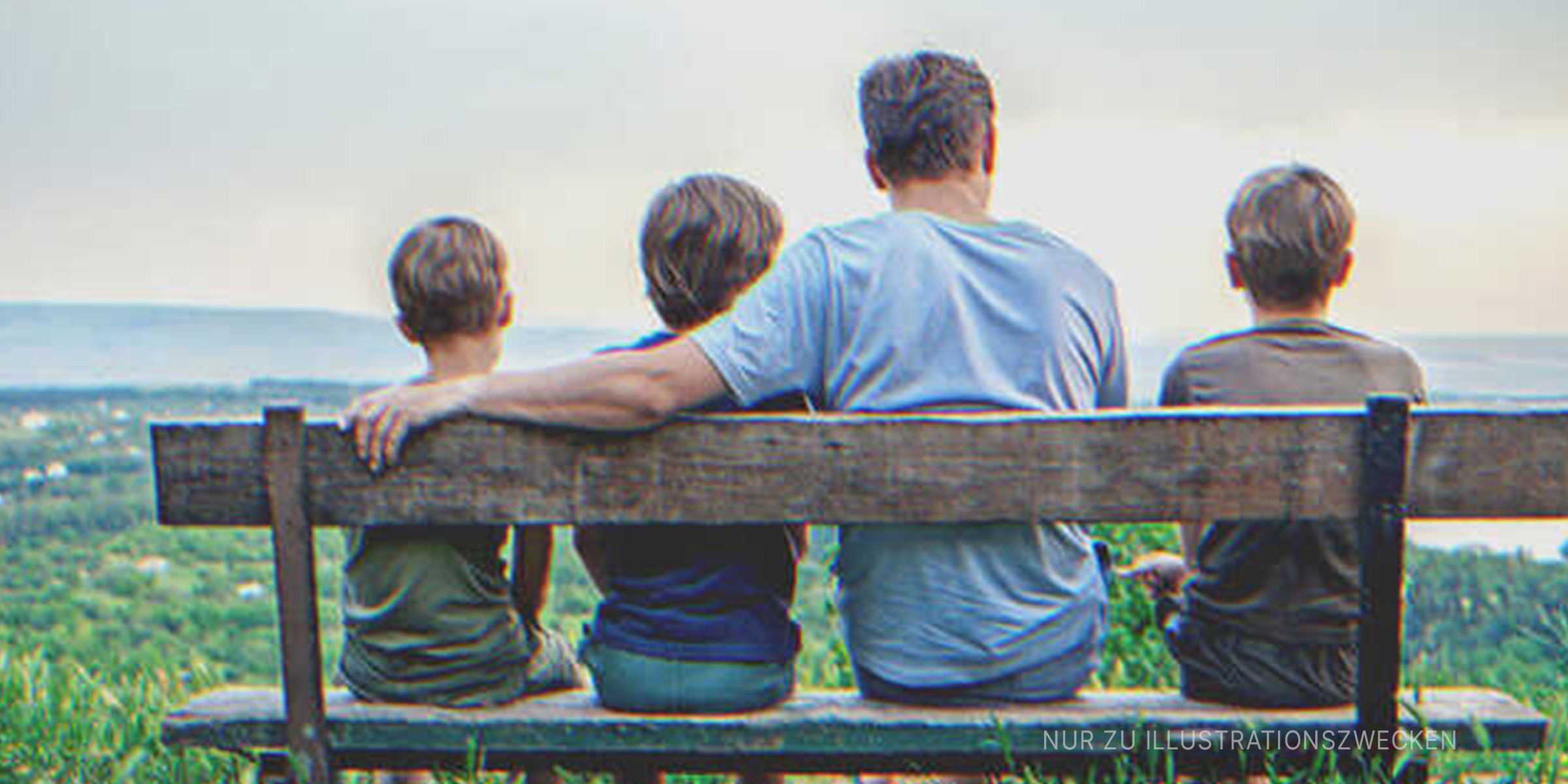 Mann sitzt mit 3 Kindern auf einer Bank. | Quelle: Shutterstock