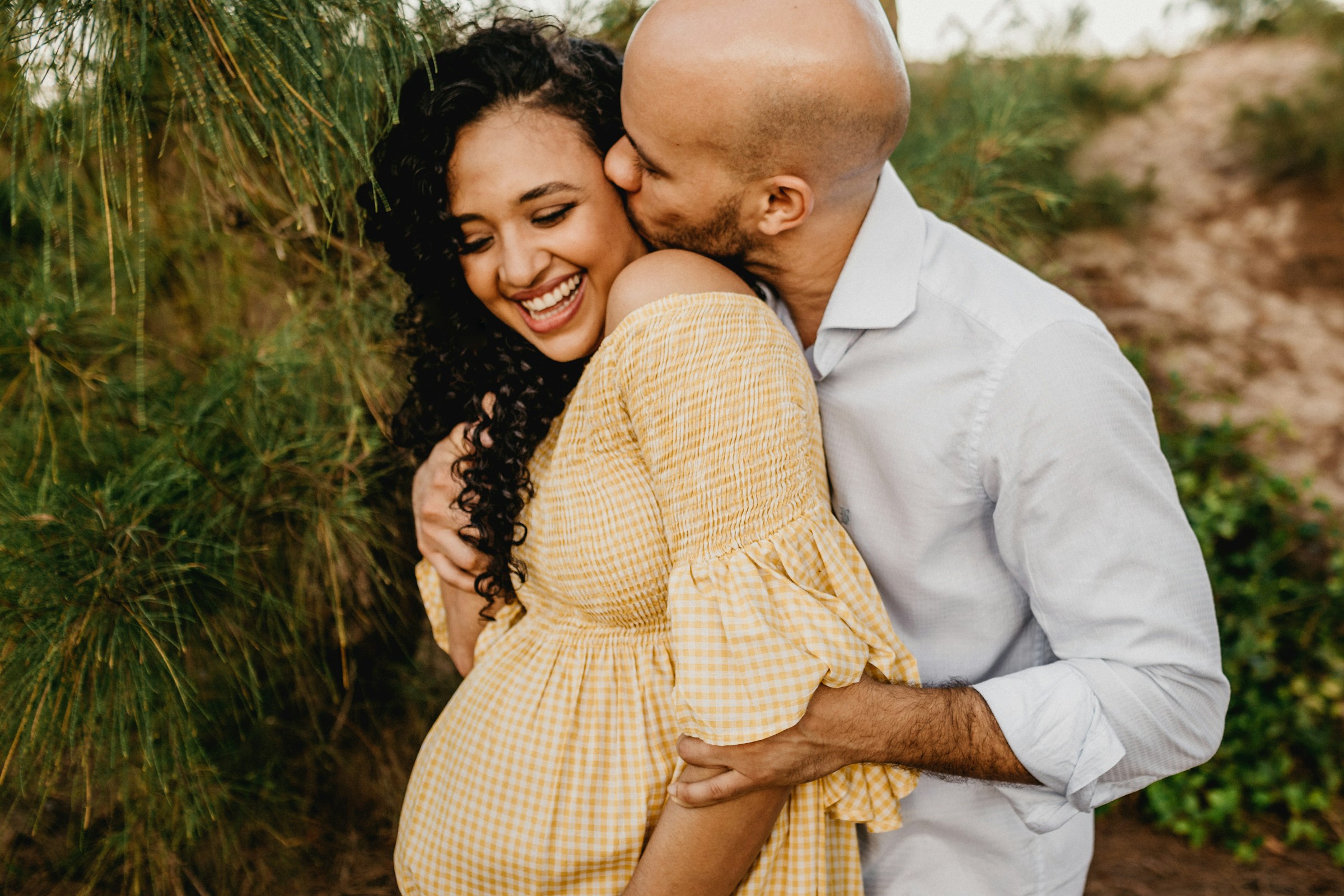 Pregnant couple hugging and kissing | Source: Unsplash