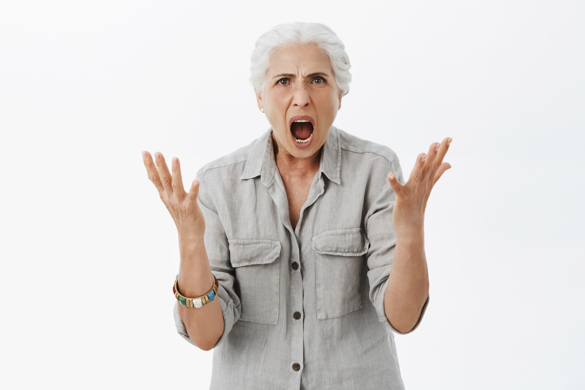 An upset older woman gesturing with her hands while shouting | Source: Freepik