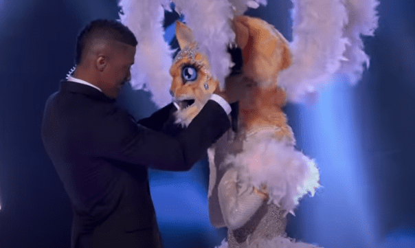 Nick Cannon helps the Kitty with the big reveal on the third season of "The Masked Singer," on May 6, 2020. | Source: YouTube/ The Masked Singer.