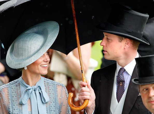 Catherine, Duchess of Cambridge and Prince William, Duke of Cambridge shelter under an umbrella as they attend day one of Royal Ascot at Ascot Racecourse | Photo: Getty Images