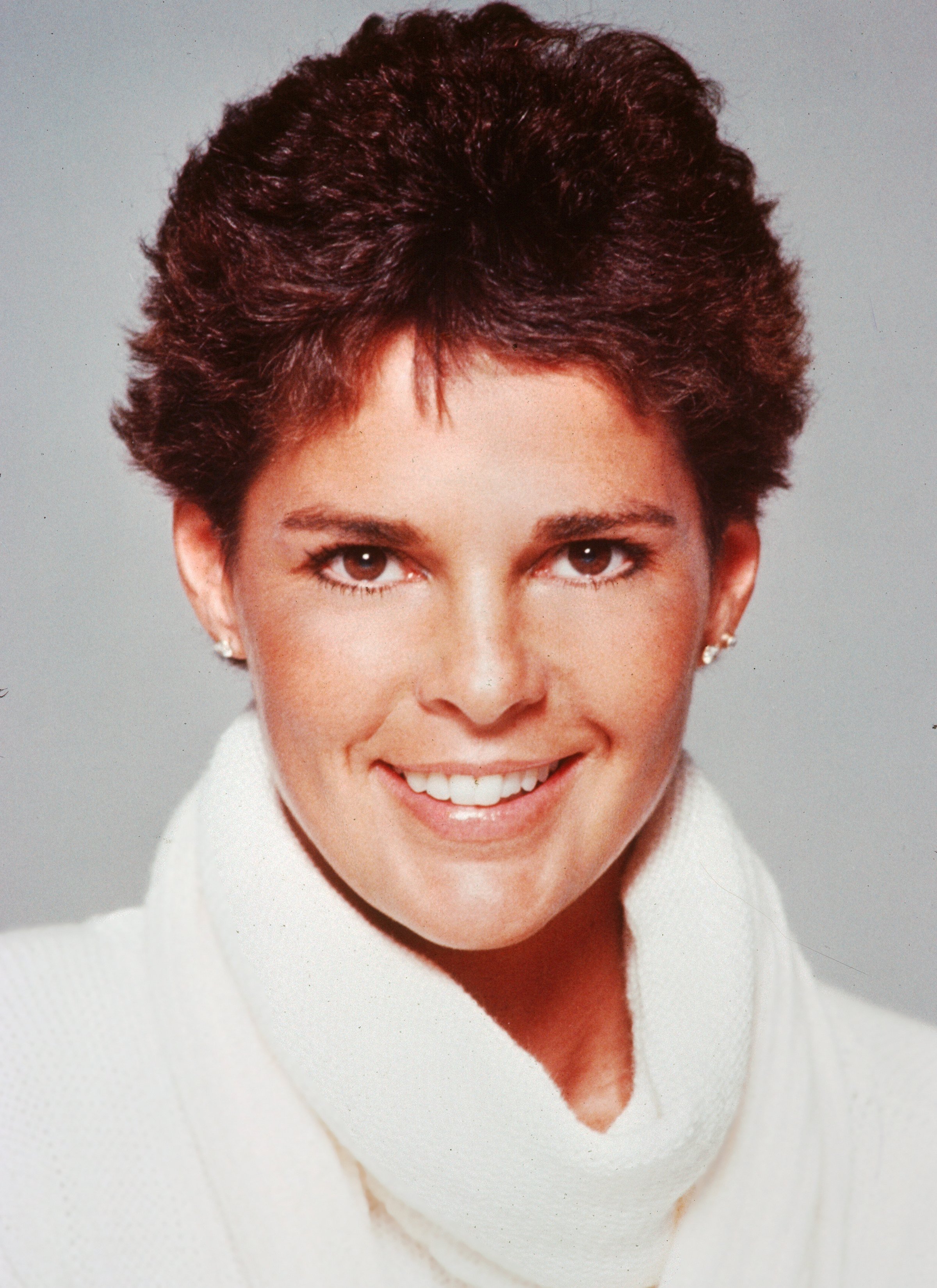 Ali MacGraw posing for a headshot in a white polo neck in 1982 in Los Angeles, California. | Source: Getty Images