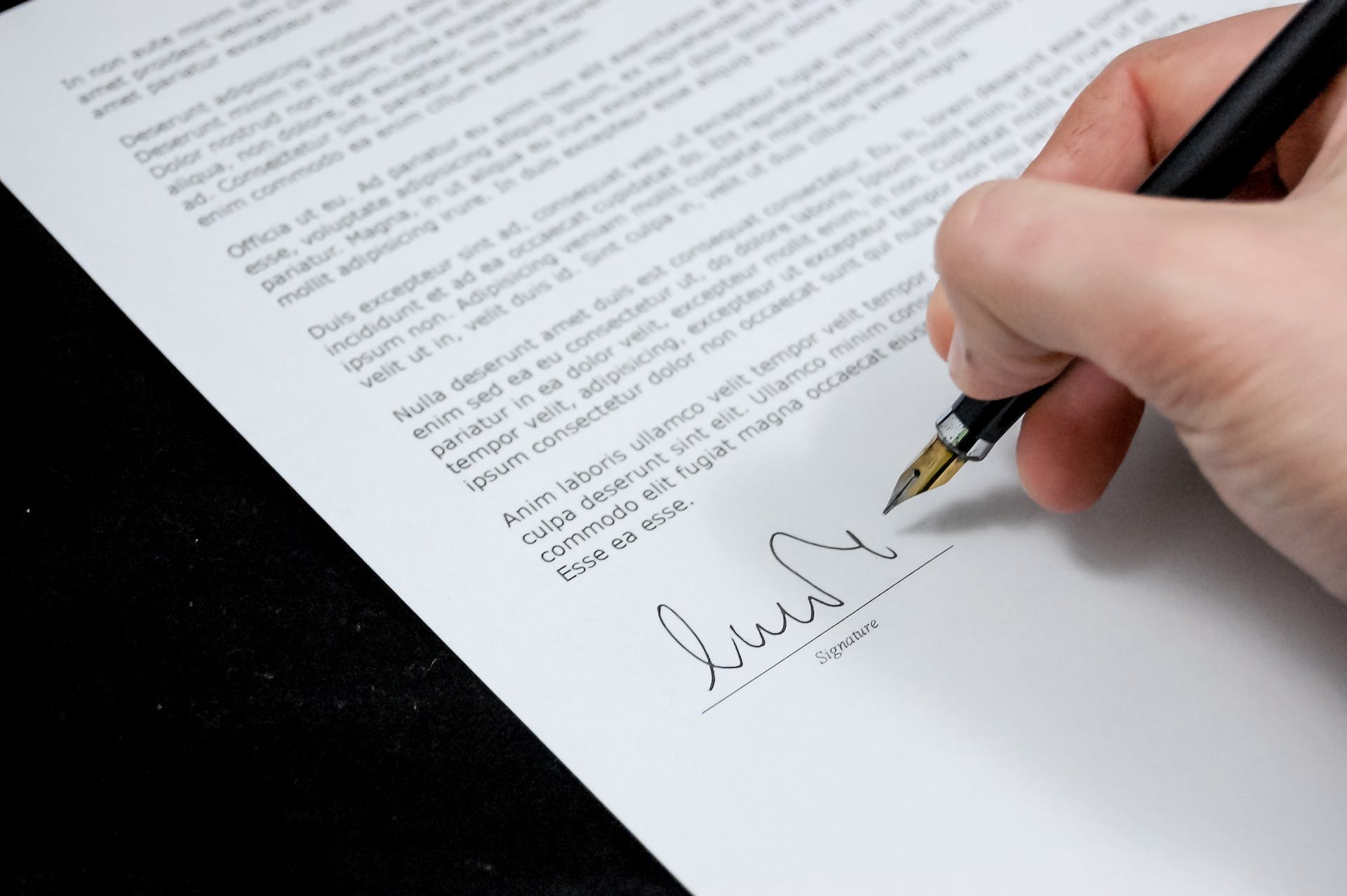 Person signing a document | Source: Pexels