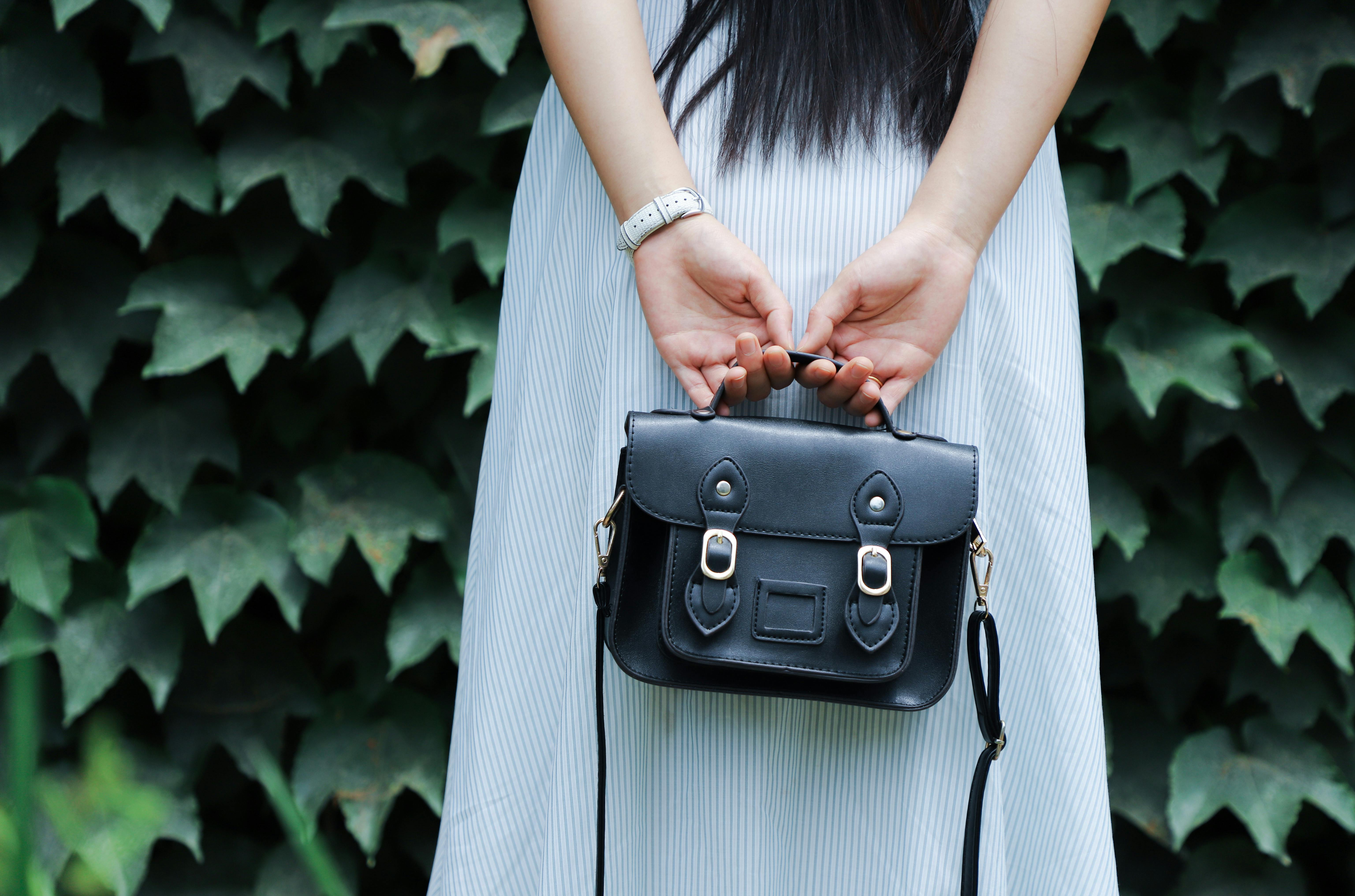 A woman holding a leather bag | Source: Pexels