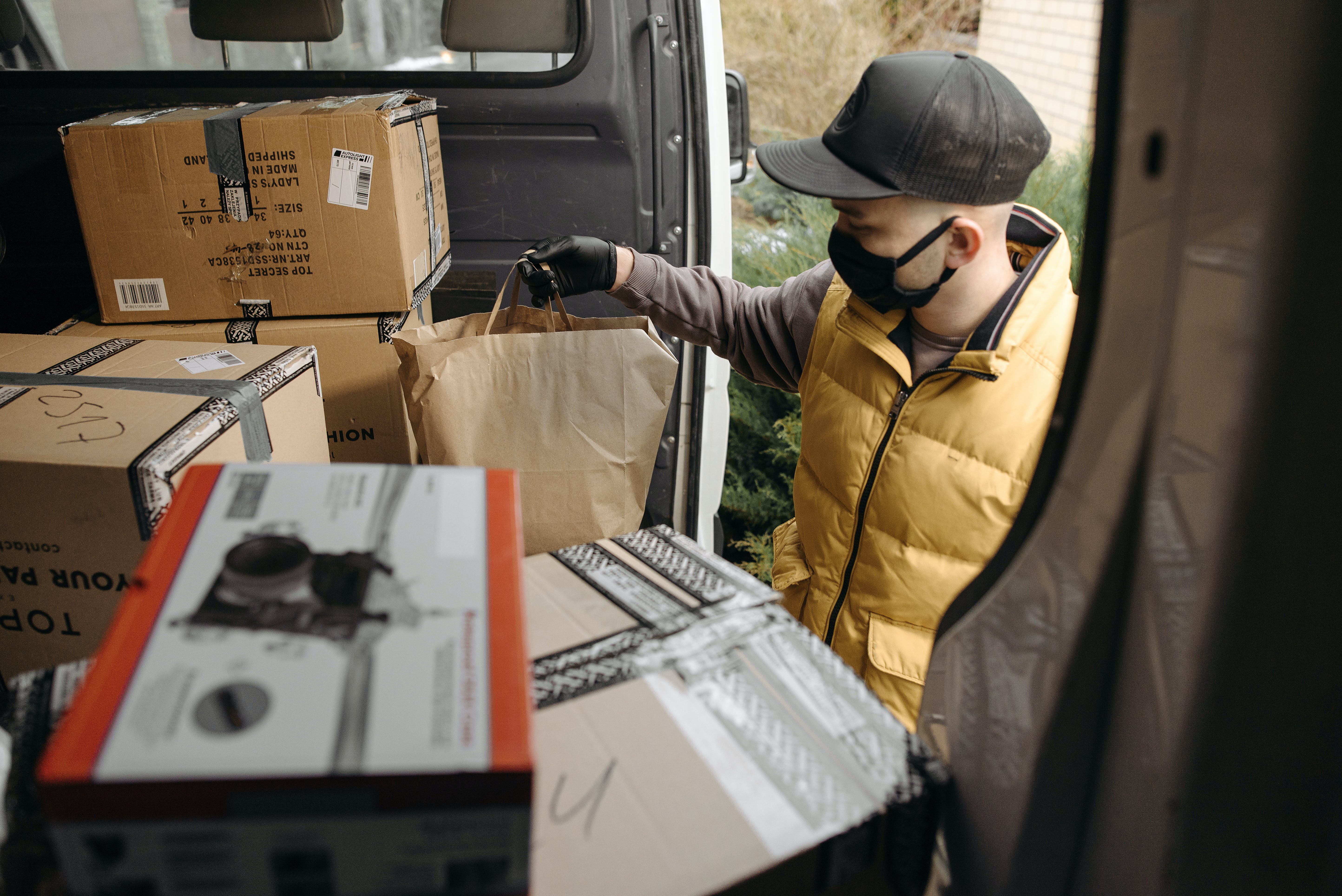 A delivery guy holding a package. | Source: Pexels