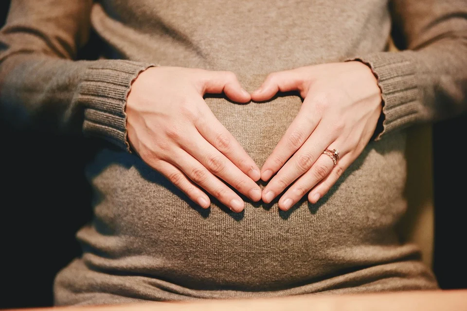 Mujer hace un símbolo de corazón con sus manos sobre su vientre de embarazada. | Foto: Pixabay