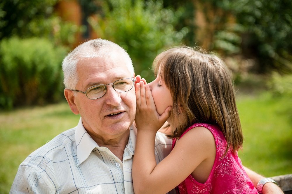 Una niña le dice un secreto a su abuelo. Fuente: Shutterstock Una niña le dice un secreto a su abuelo. Fuente: Shutterstock
