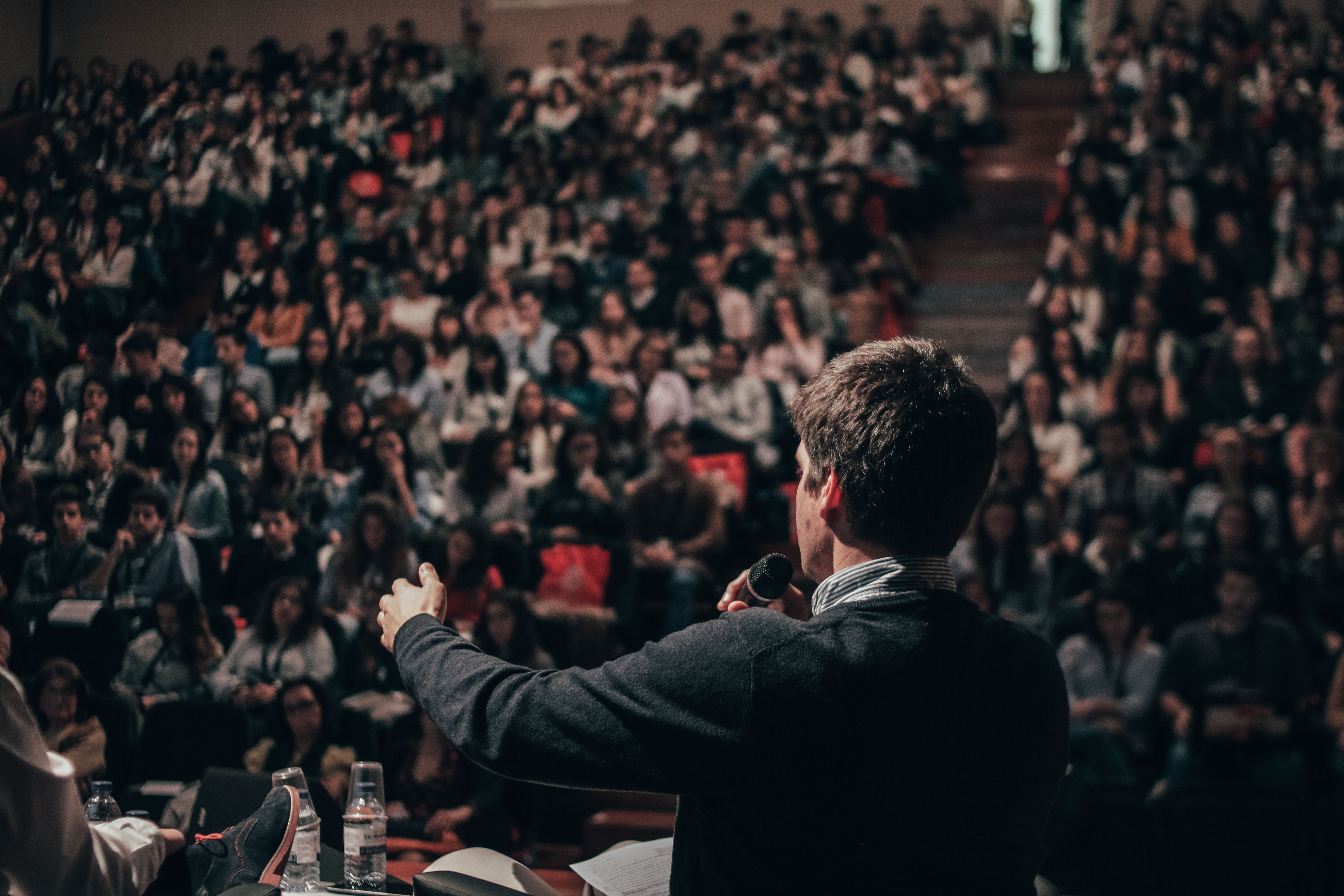 Man speaking in front of an audience. | Source: Unsplash