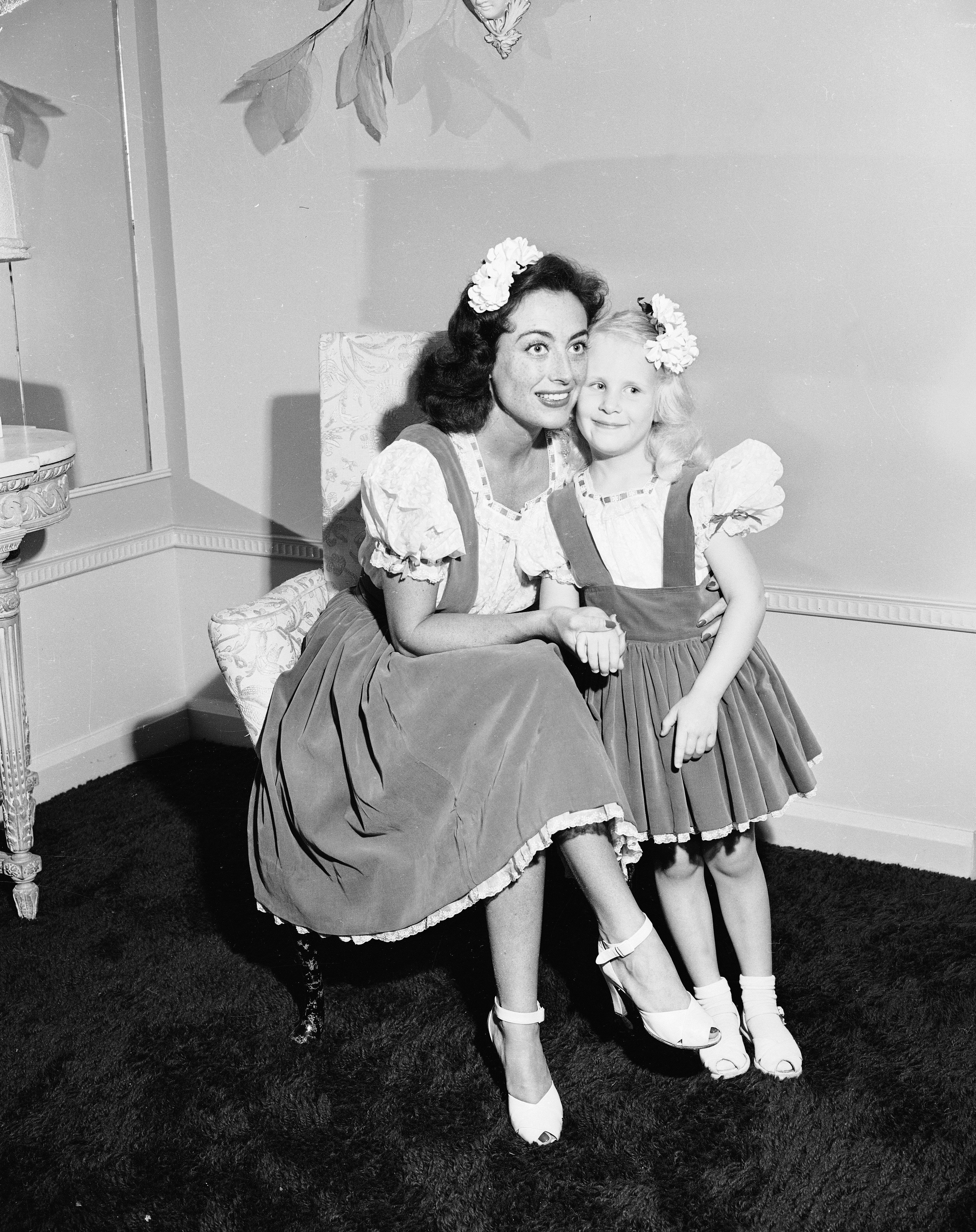 Joan Crawford umarmt ihre Adoptivtochter Christina in passenden Outfits, Juni 1944. | Quelle: Getty Images