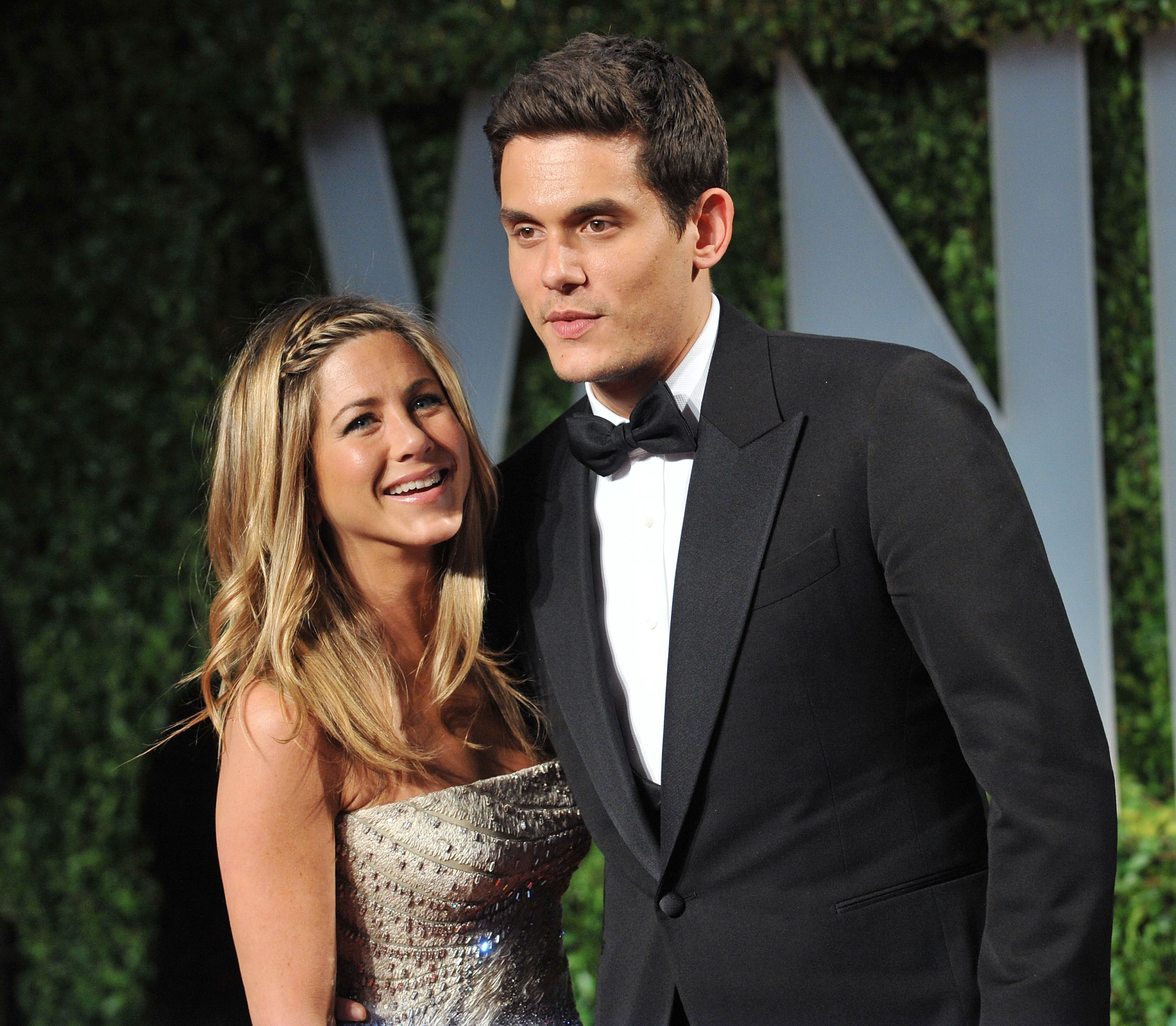 Jennifer Aniston posed with John Mayer at the Vanity Fair Oscar Party held in West Hollywood in February 2009. She wore a sparkling strapless gown with her long, golden hair styled in loose curls over one shoulder.