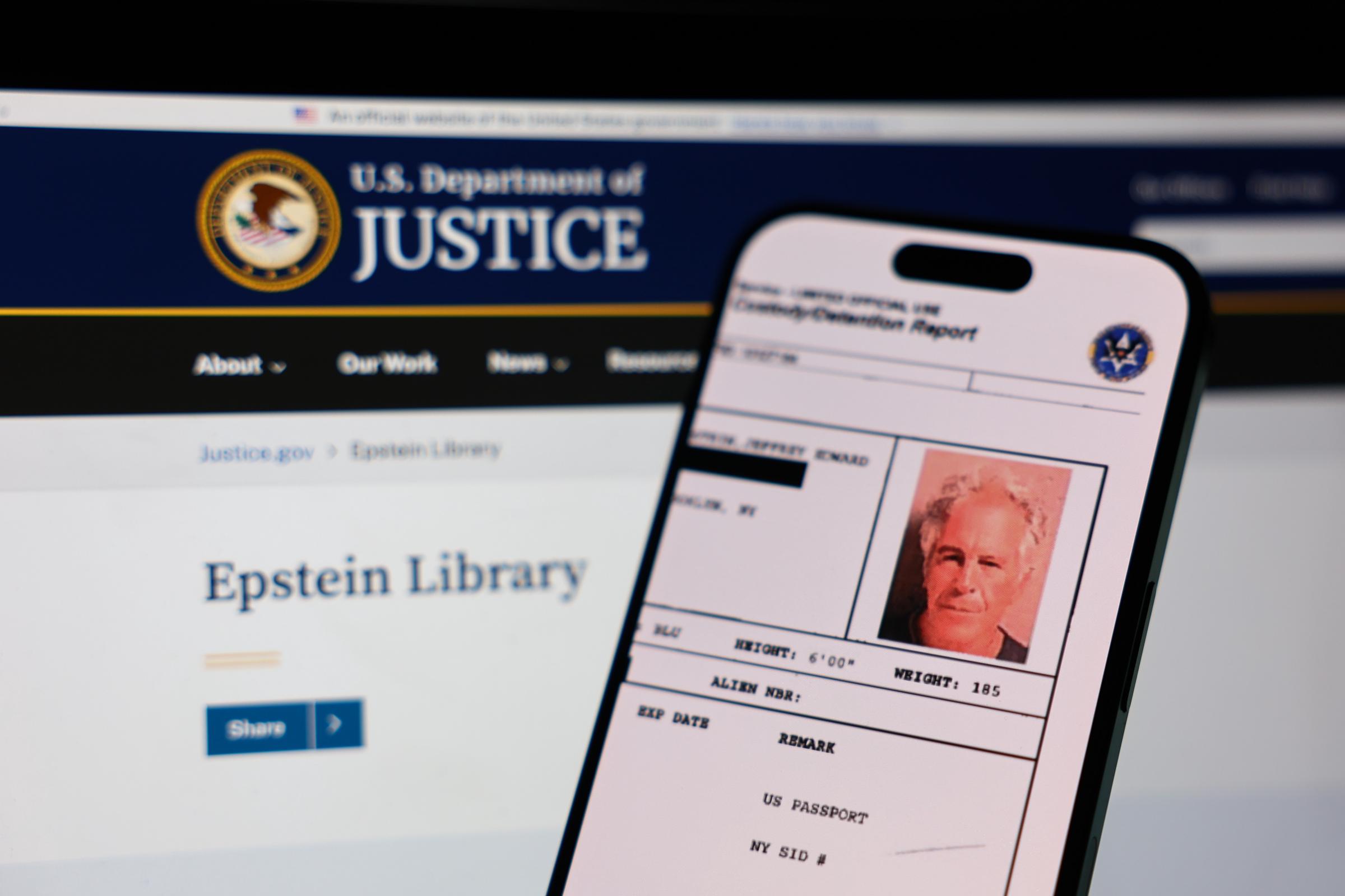 The U.S. Department of Justice Epstein Library webpage is displayed on a laptop screen alongside related documents shown on a phone on February 4, 2026 | Source: Getty Images