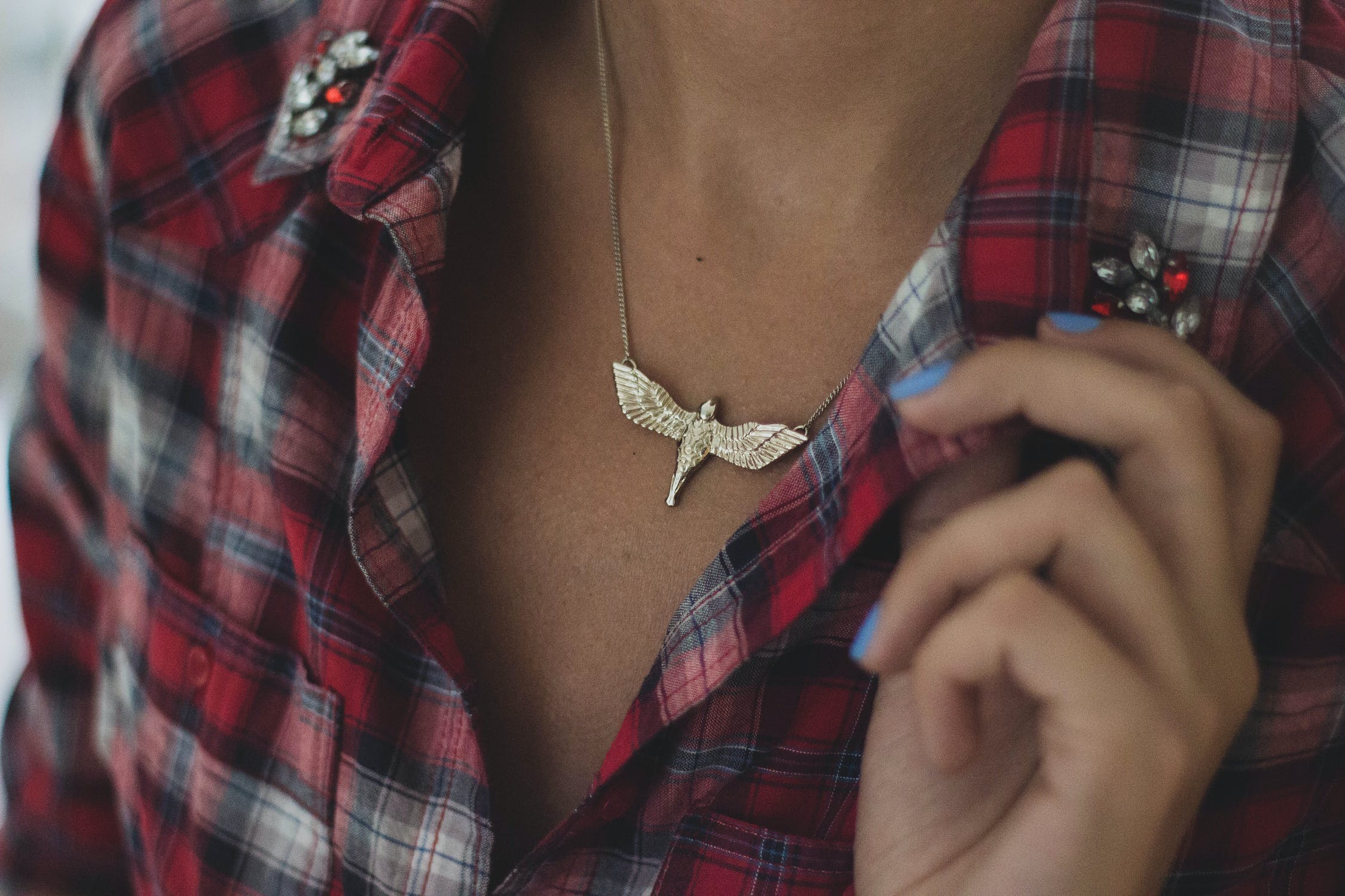 Mujer usando camisa de cuadros con broches florales. | Foto: Pexels